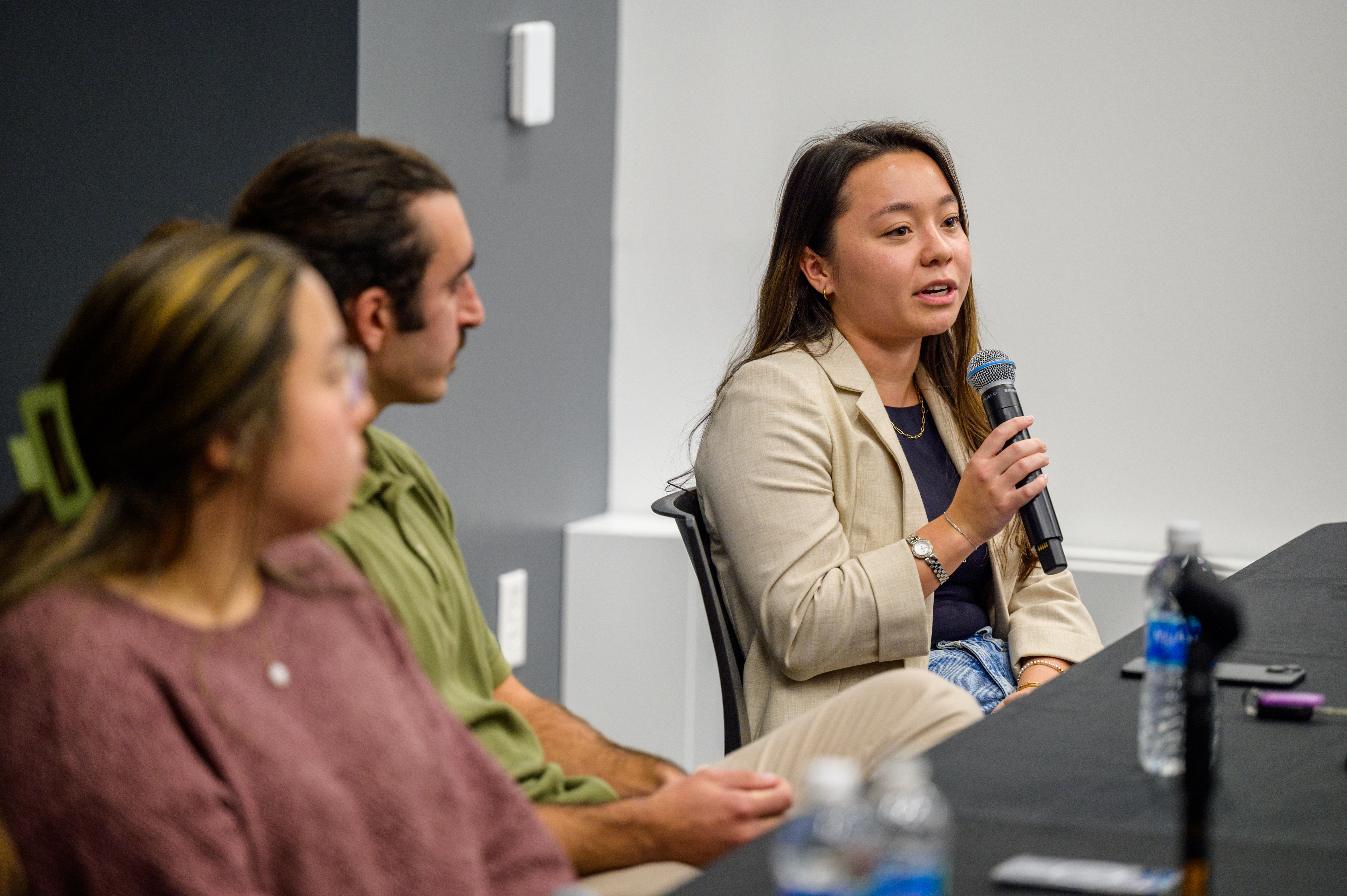 Alum speaks into microphone at 5 Under 5 Alumni Panel event