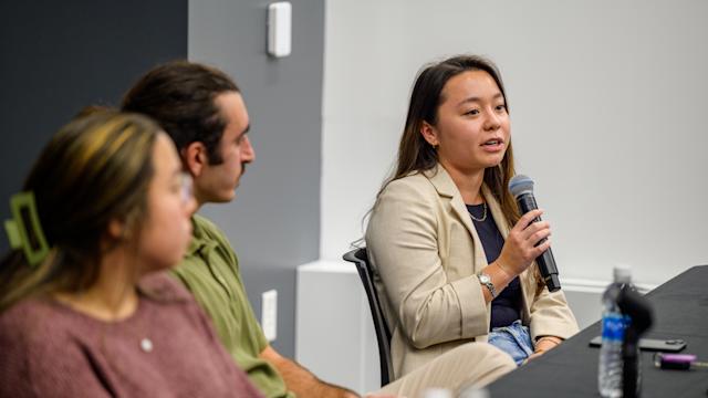 Alum speaks into microphone at 5 Under 5 Alumni Panel event