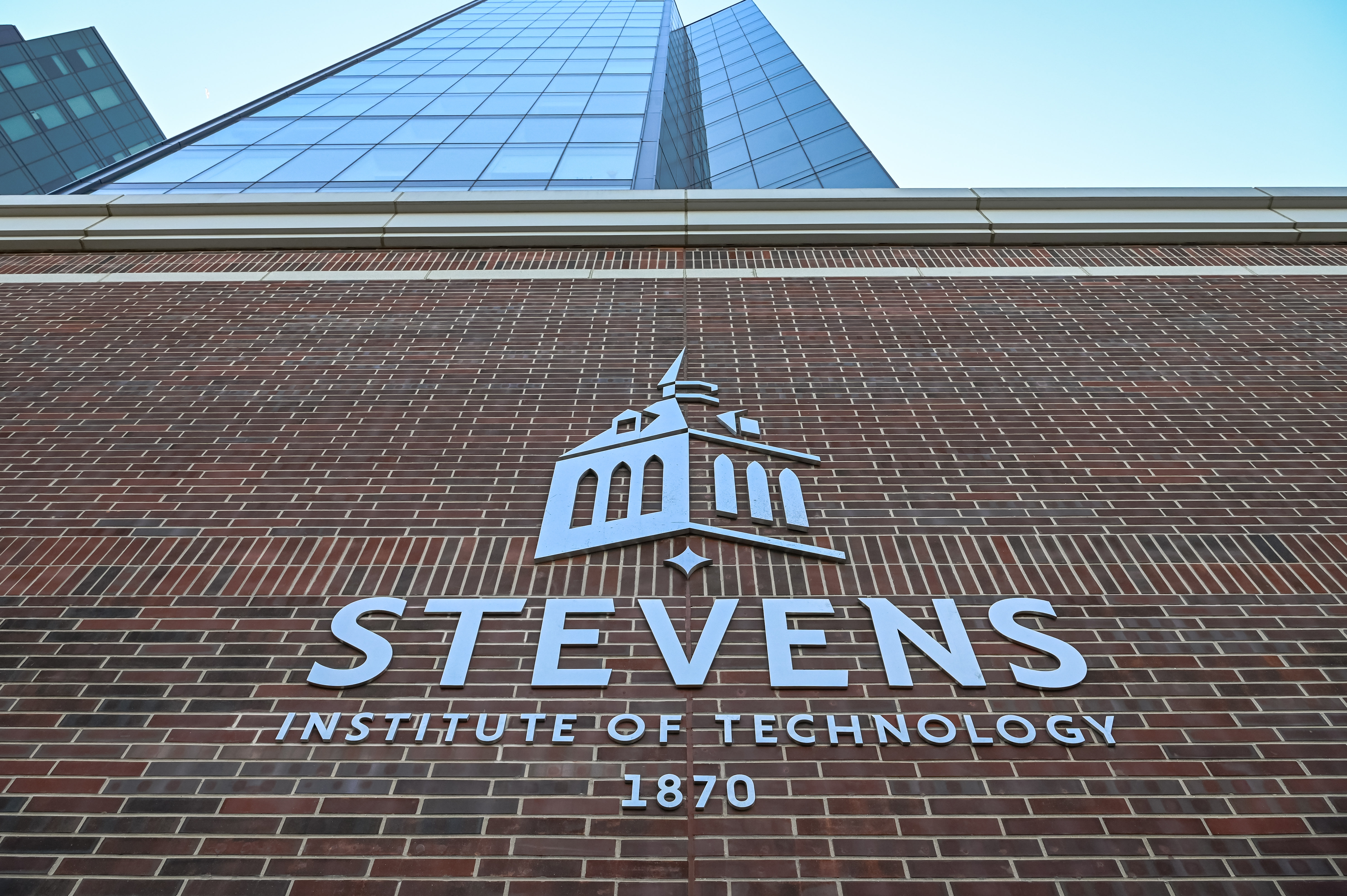 Silver Stevens logo against a brick wall with the residential towers in the background.