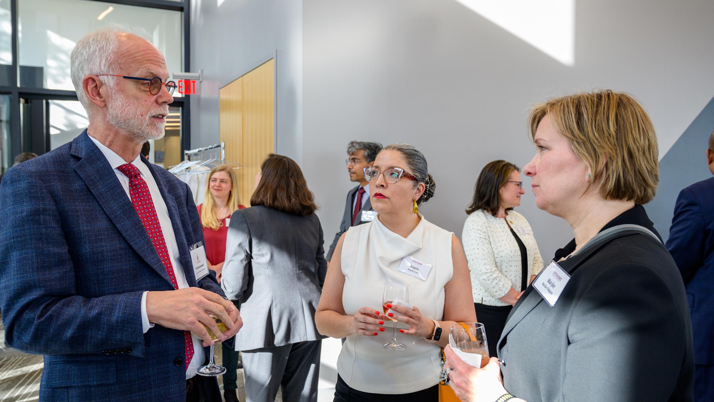 Two alums connect with Vice Provost Ed Synakowski at a networking event