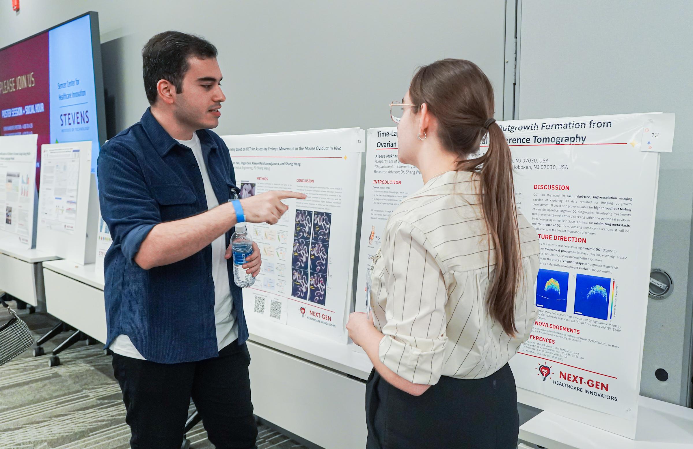 Two students discuss a poster presentation at the NextGen Healthcare Innovators Symposium in 2024.
