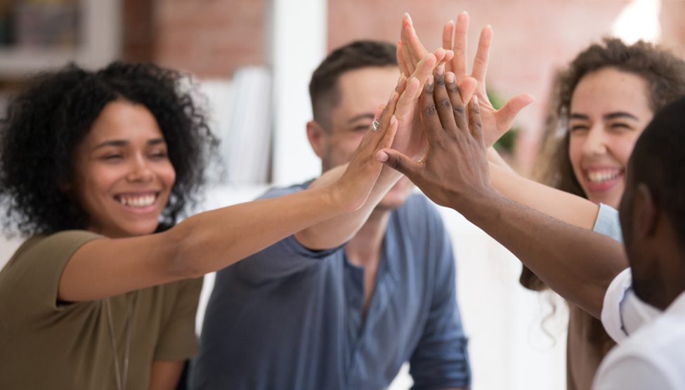 Diverse group of colleagues put there hands together to show unity  