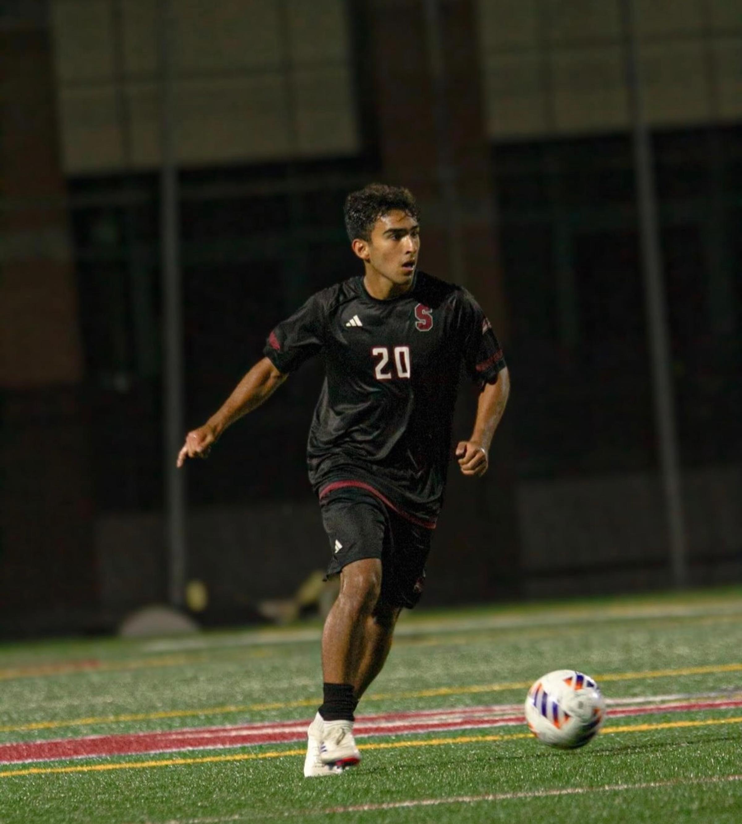 Ethan Hagen playing soccer, running on the field alone at night after the ball