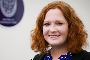 A headshot of a student smiling in front of a white background