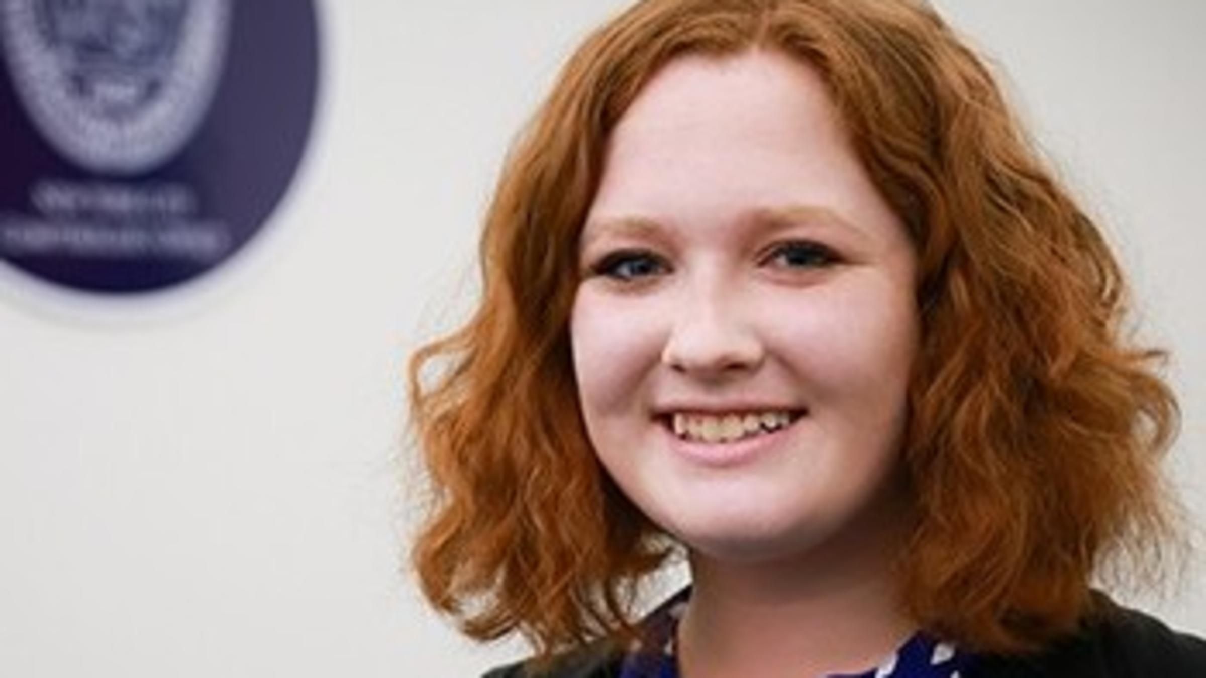 A headshot of a student smiling in front of a white background