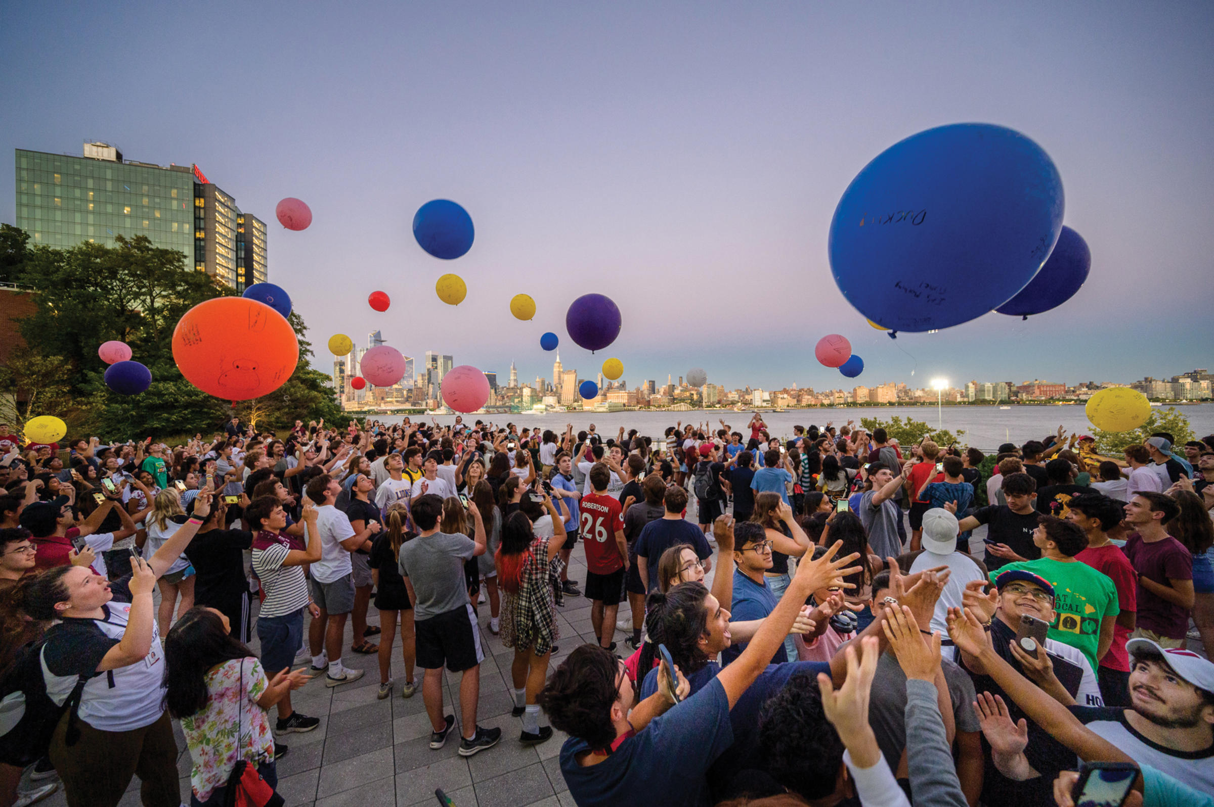 Students release balloons at dusk on campus.
