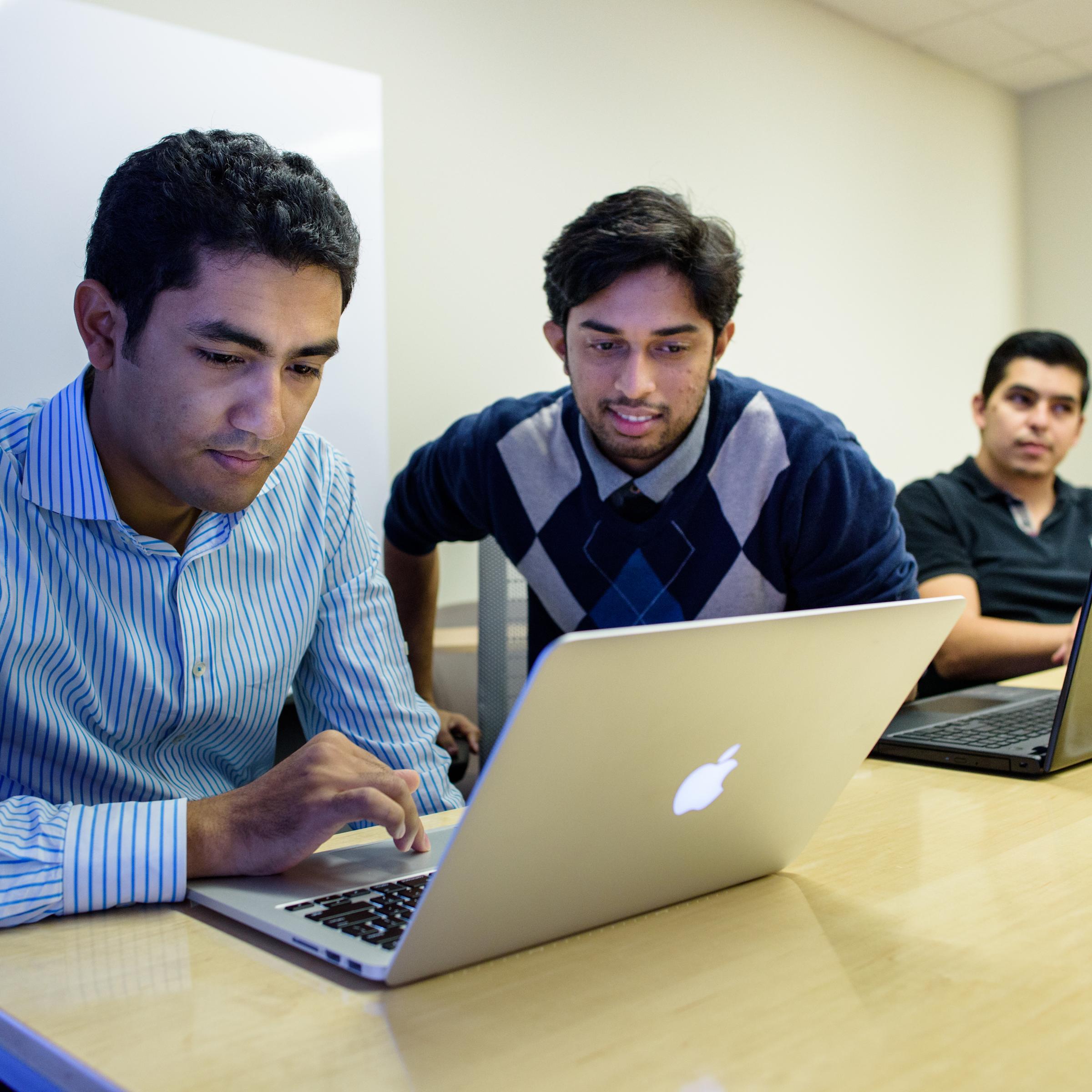 Five students present a project to their professor on a screen