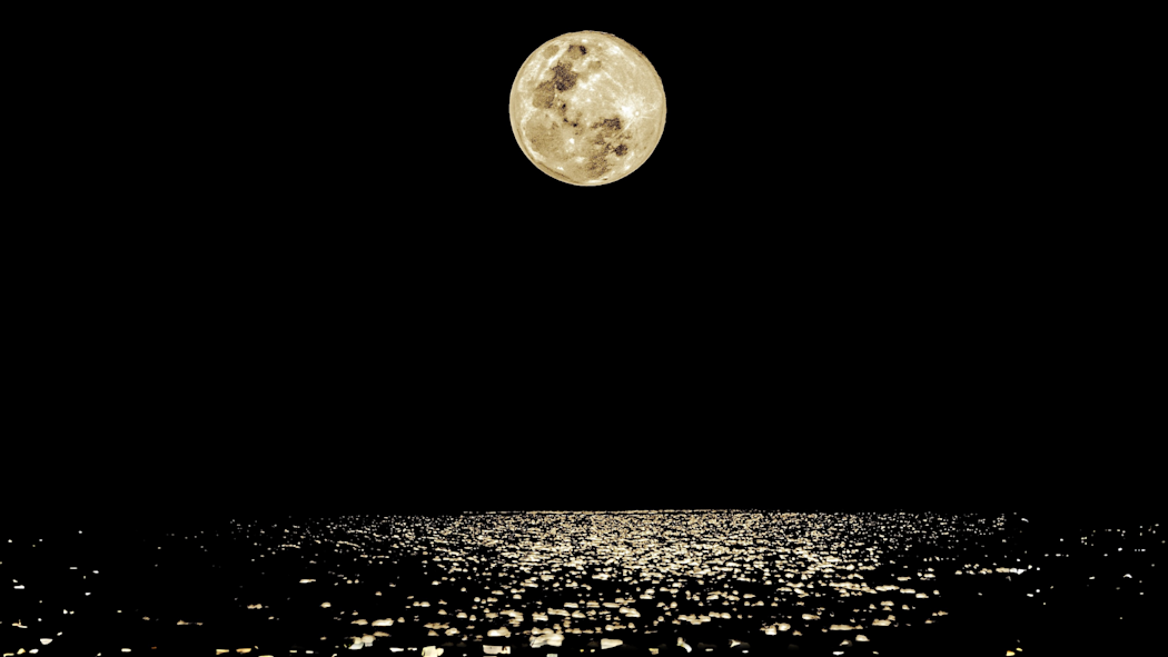 the moon at night over a body of water
