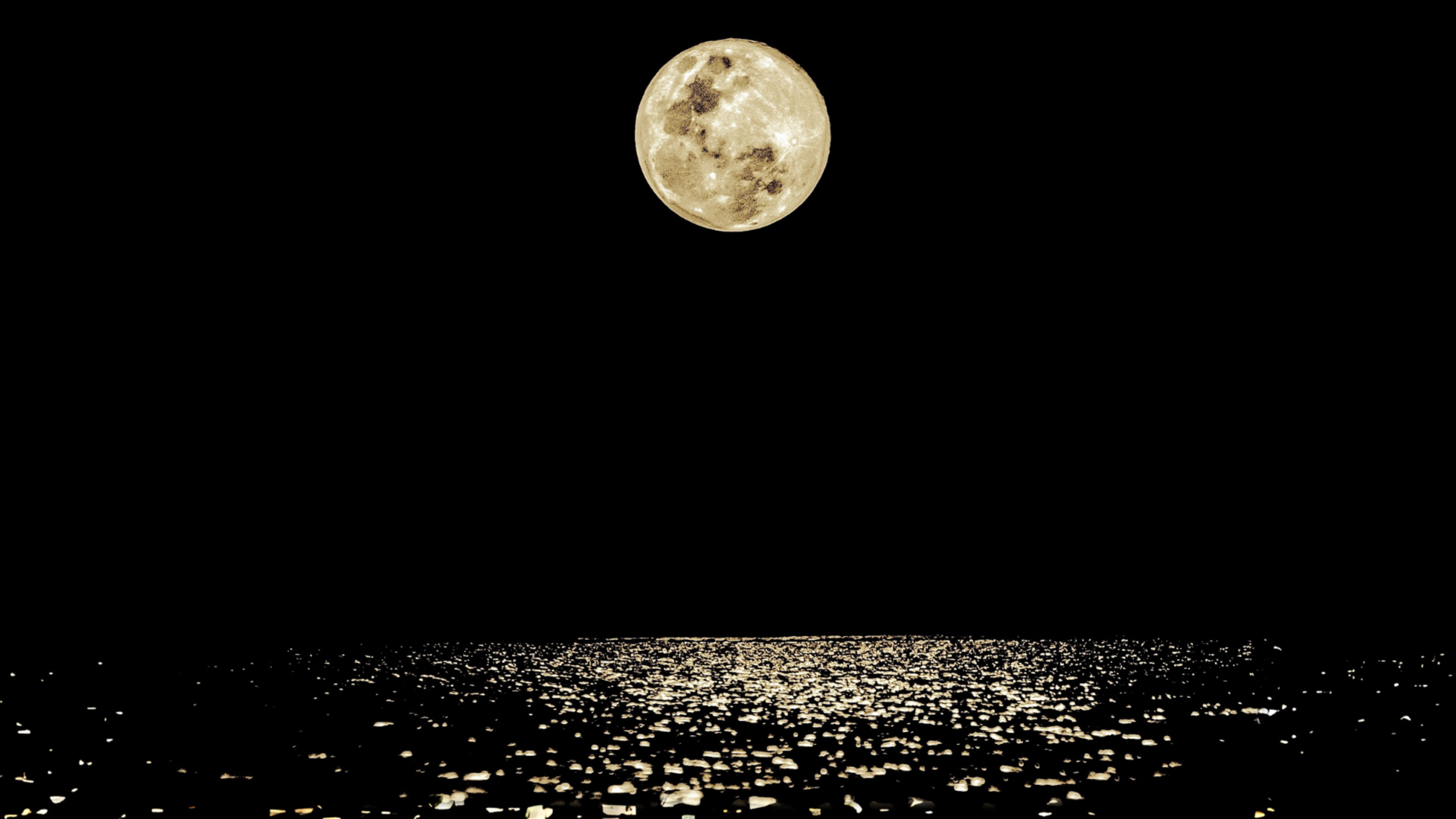 the moon at night over a body of water