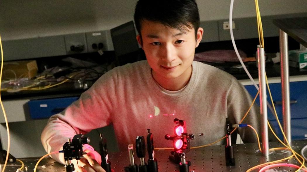 A student in the CQSE laboratory sitting in front of a laser