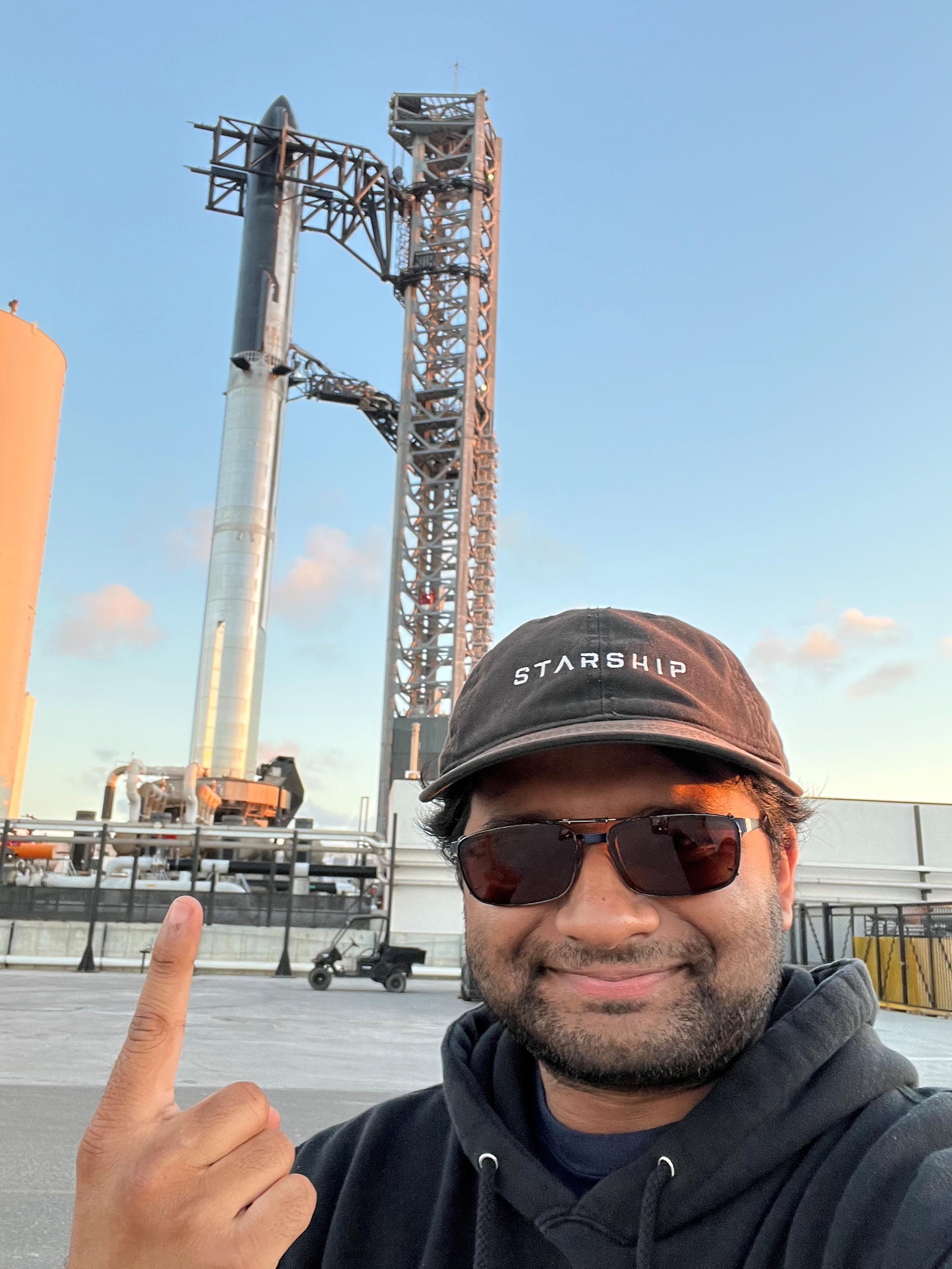 Arjun Krishna takes selfie pointing to SpaceX rocket