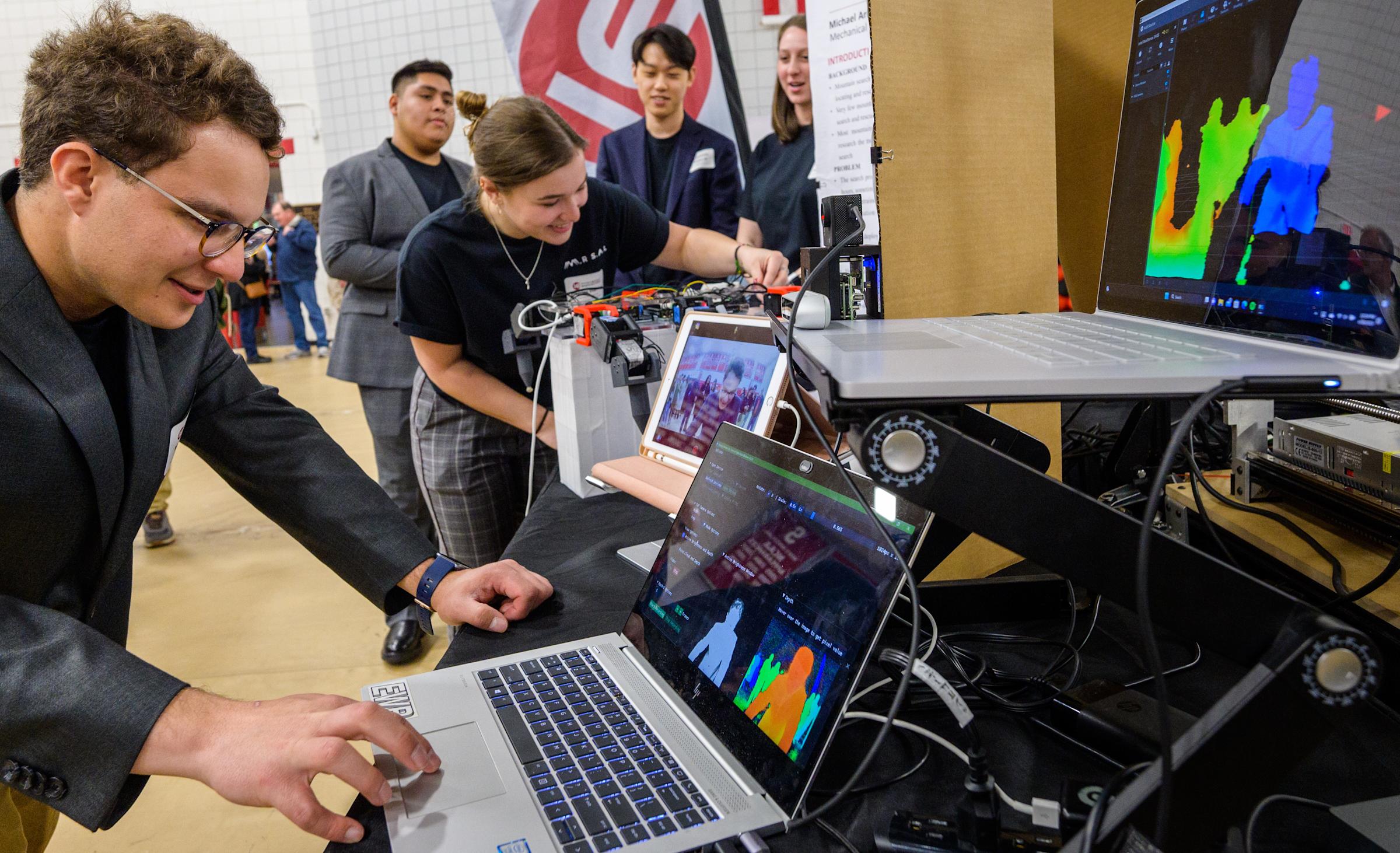 Student at multiple computer screens in Canavan Arena during 2023 Stevens Innovation Expo