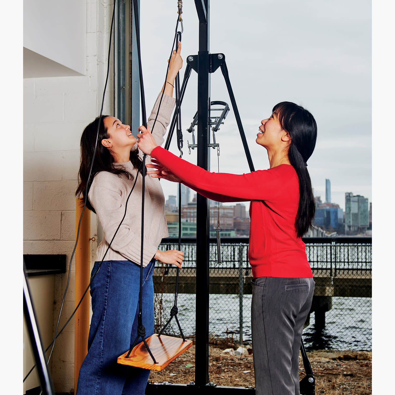 Two students work with an engineering device.