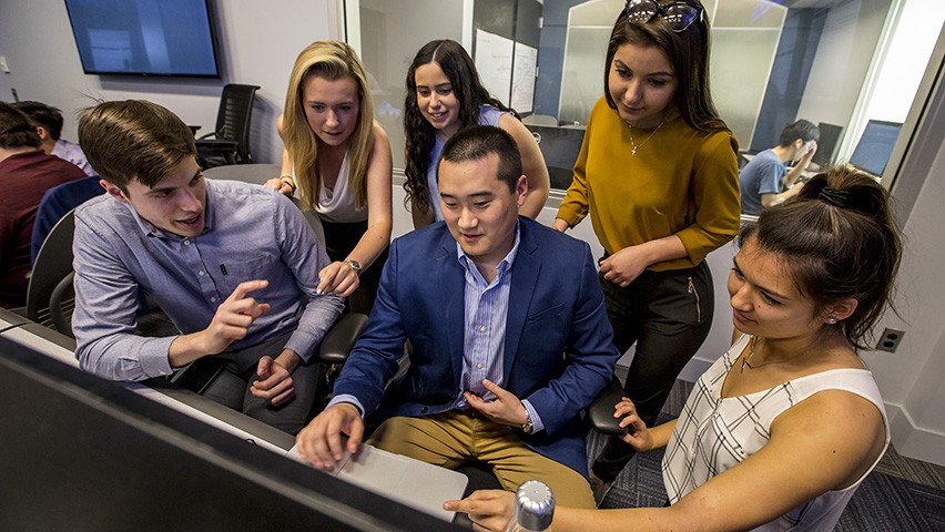 Group of students collaborating at a computer.