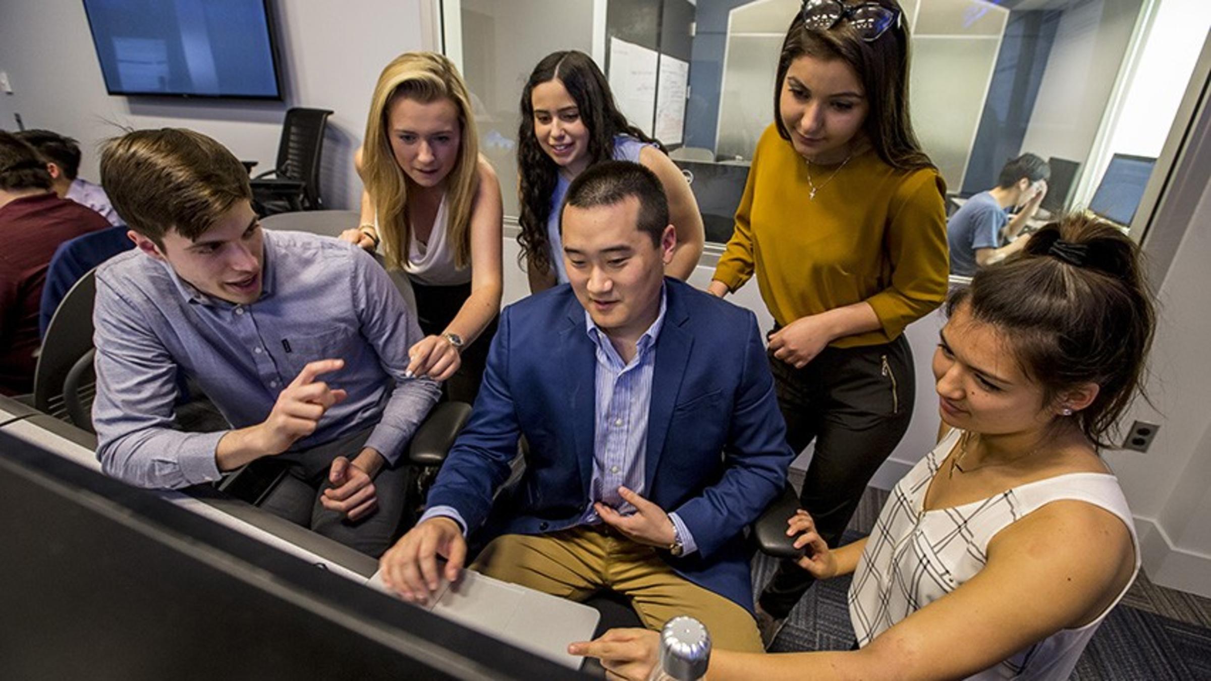 Group of students collaborating at a computer.