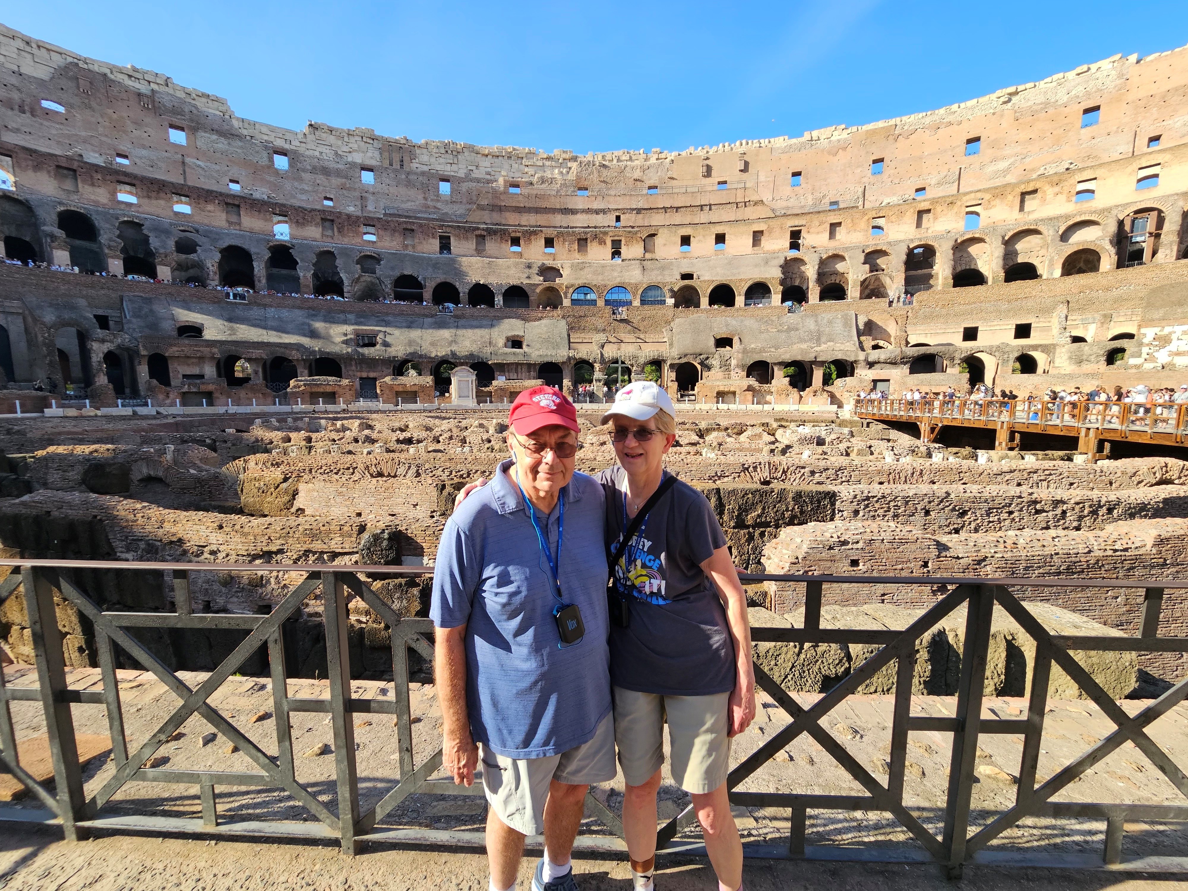 Barb and Jim Moraseski ’73 M.S. ’73 pose for picture together while in front of tourist destination of historical ruins, while Jim wears a Stevens baseball cap