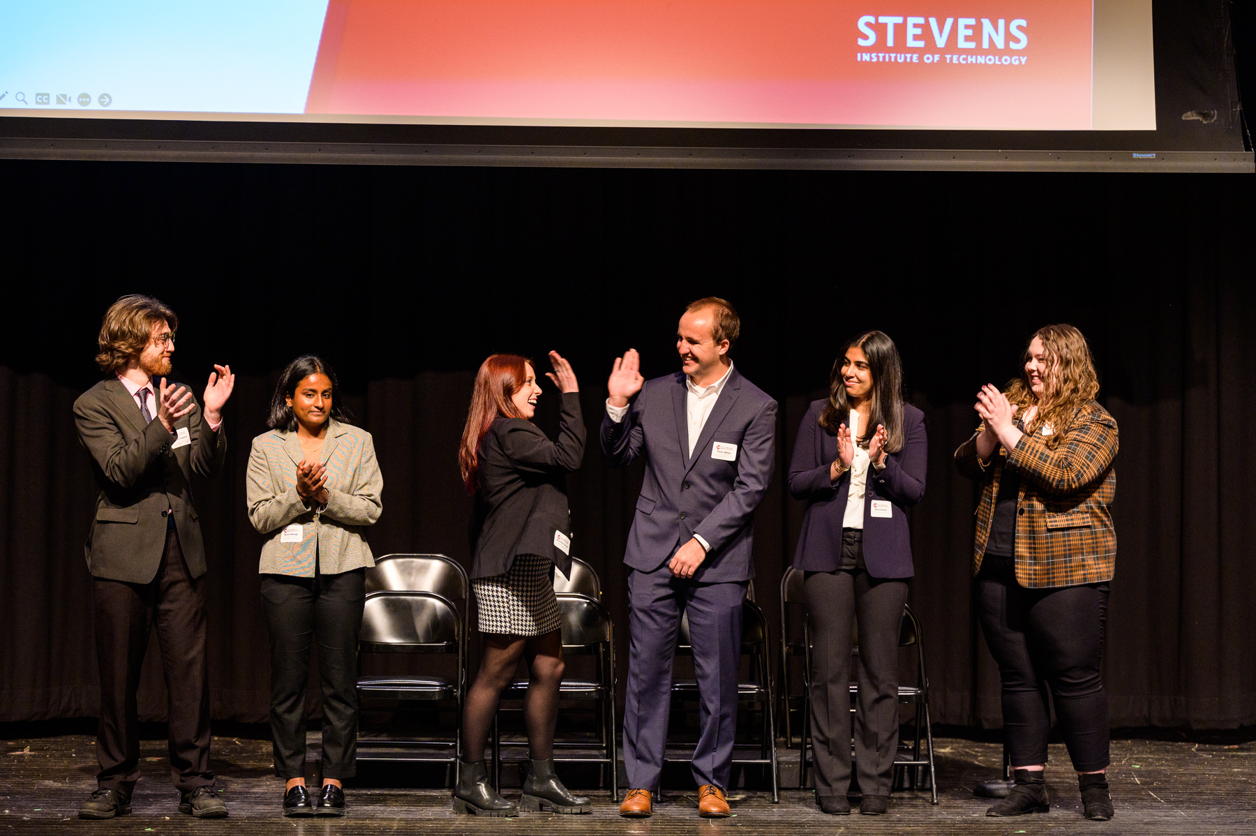 Students celebrate on stage at Innovation Expo