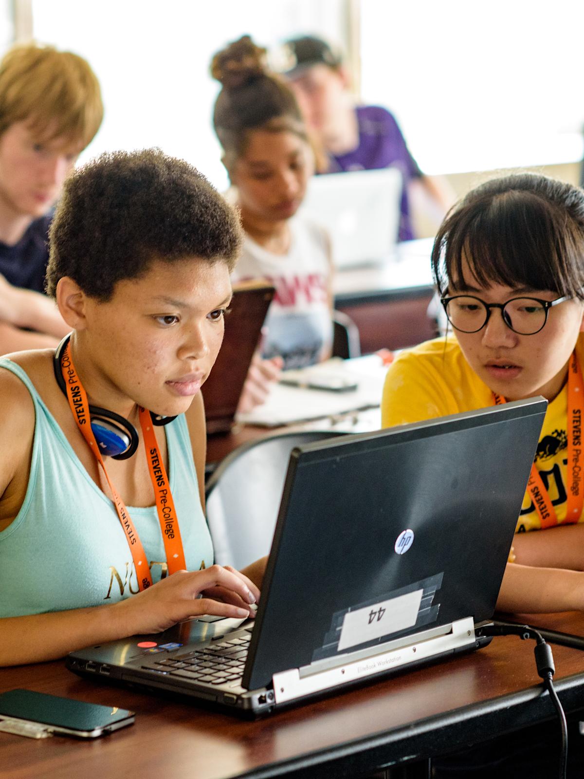 Two high school students examine information on a laptop while visiting Stevens.