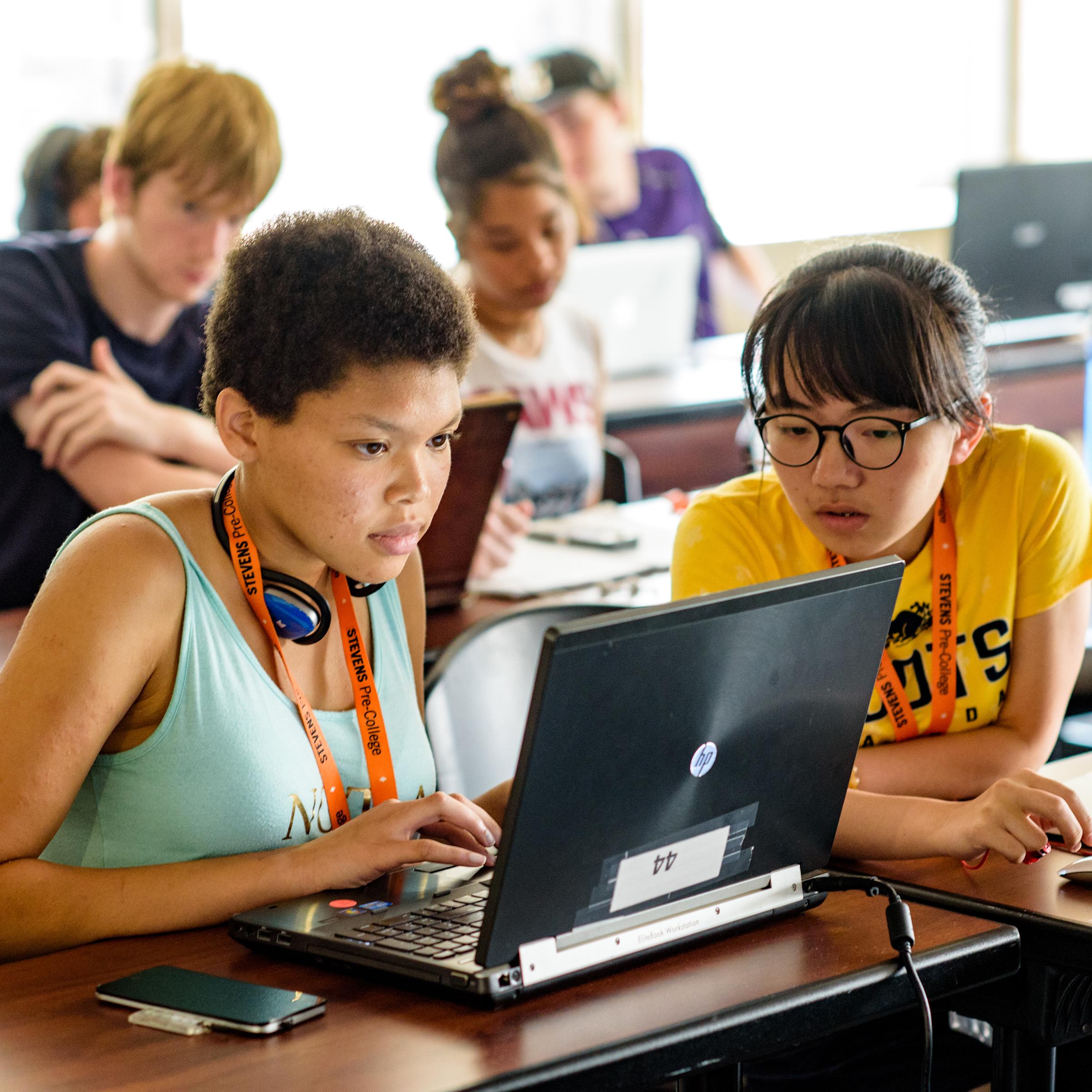 Two high school students examine information on a laptop while visiting Stevens.