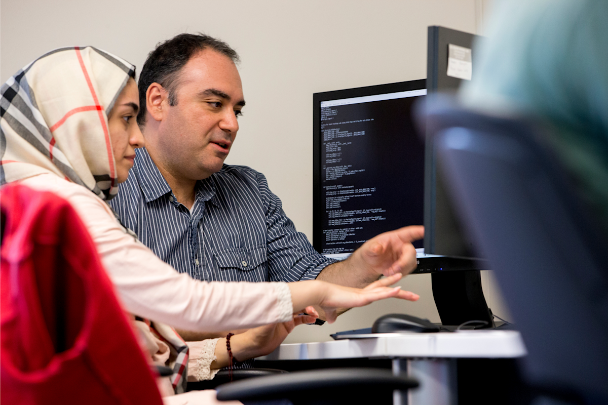 Woman and man pointing at a computer
