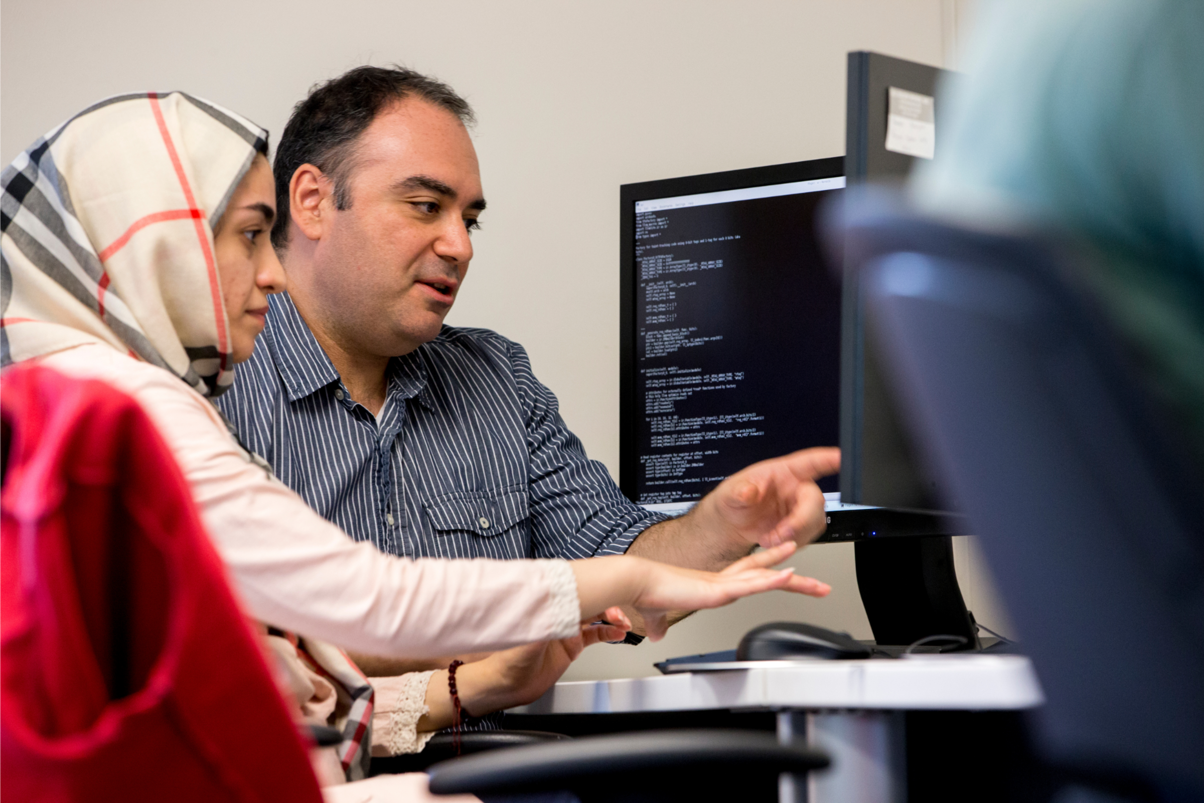 Woman and man pointing at a computer