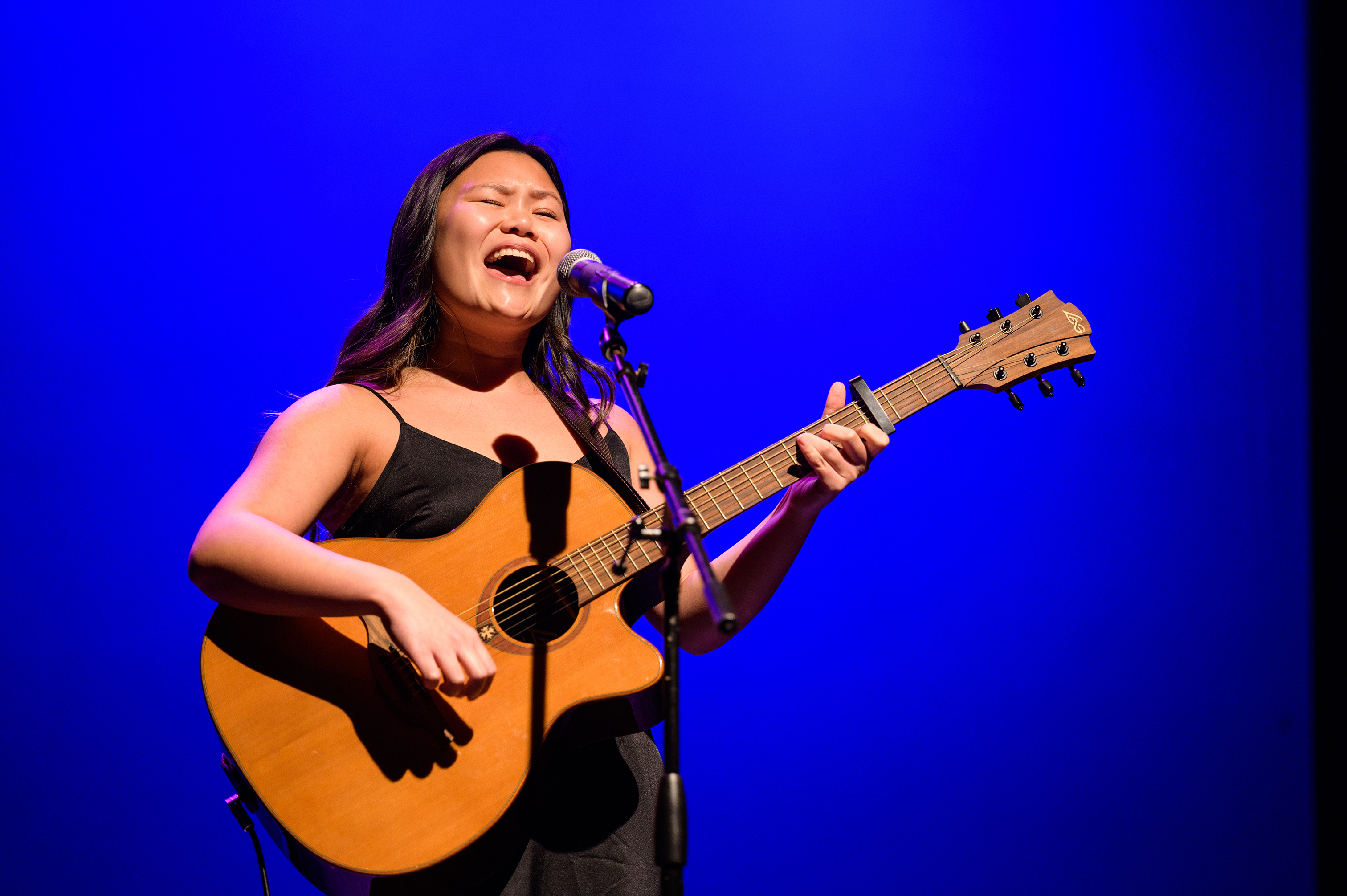 Student sings while playing guitar