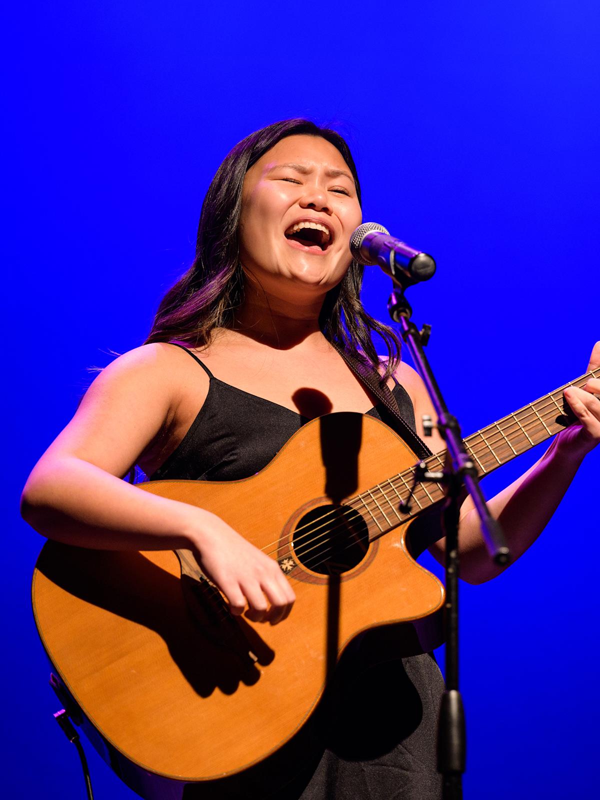 Student sings while playing guitar