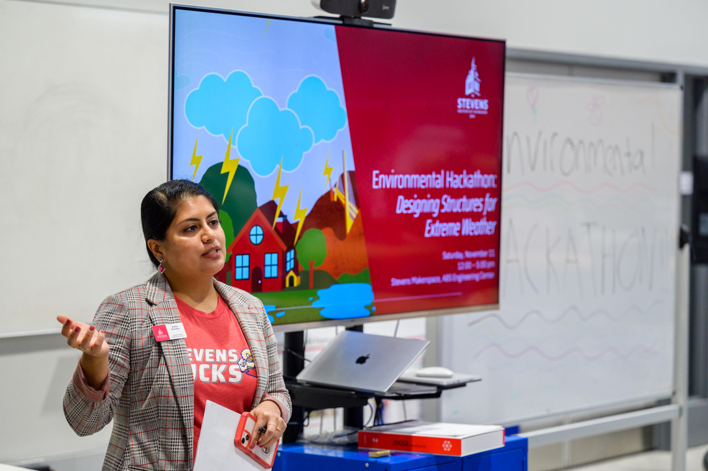 Photo of Rekha Manohar speaking in front of a screen