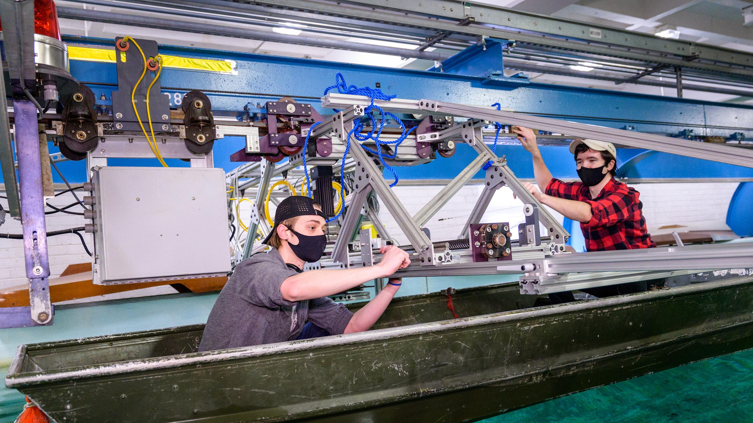 Students in boat in testing facility make adjustments