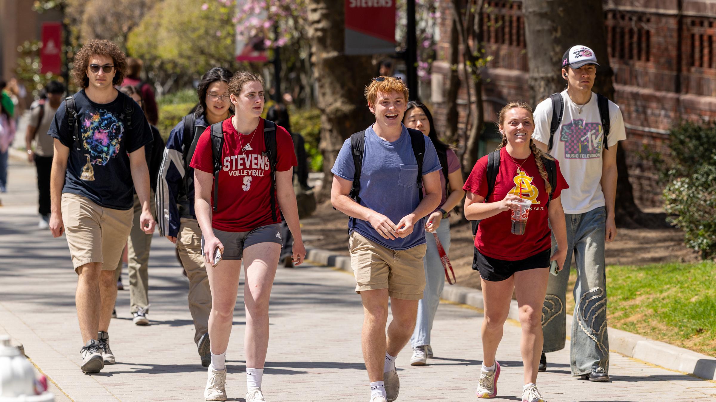 Students walk together smiling on campus