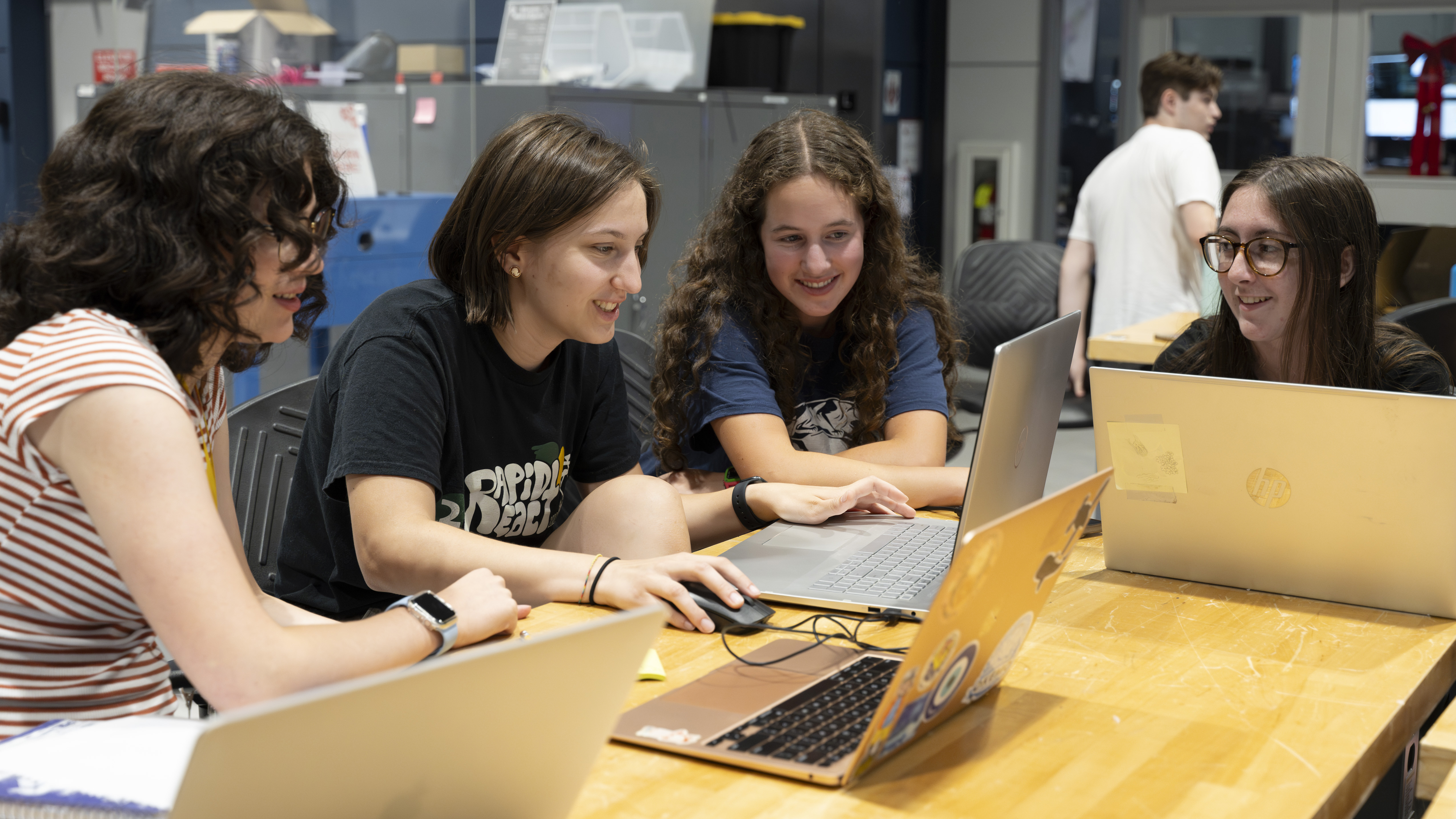 4 female students working on laptops