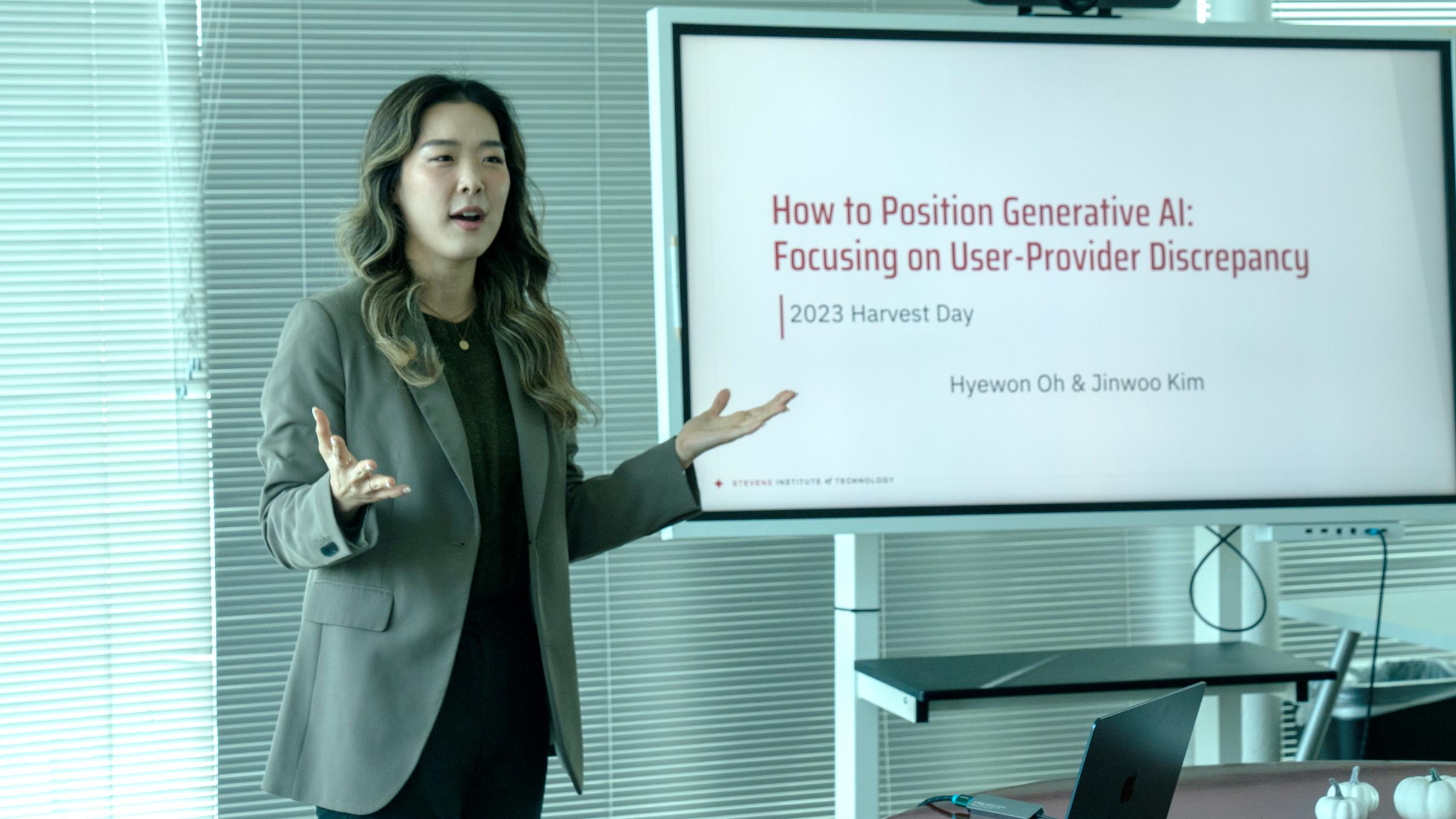 Hyewon Oh stands to the left of a smart board that reads How to Position Generative AI: Focusing on User-Provider Discrpepancy