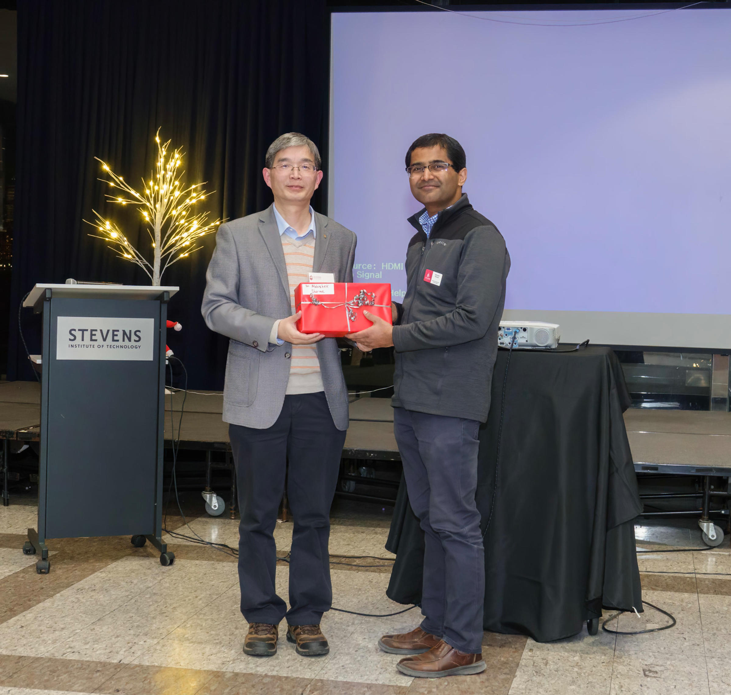 Yong Zhang and Abhishek Sharma standing together holding an award