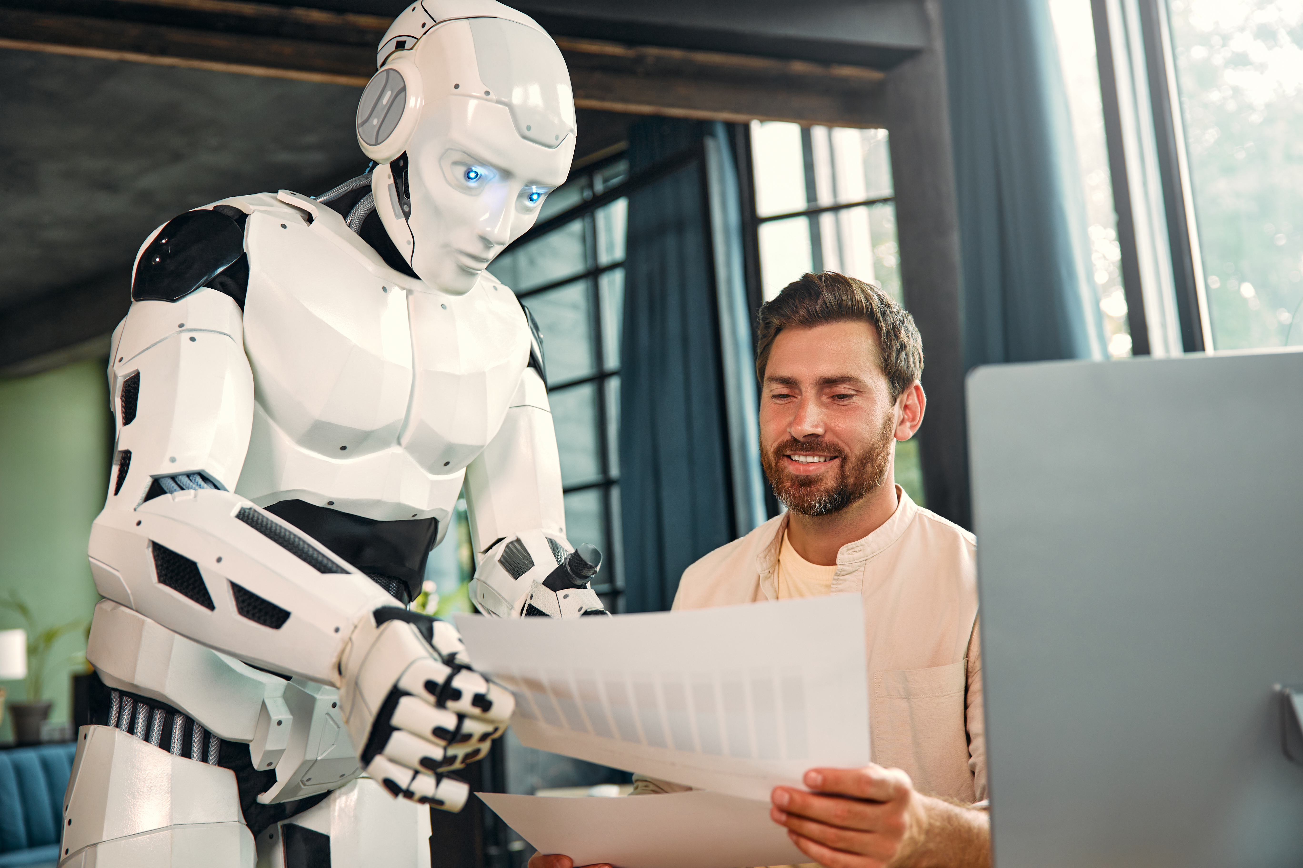 A robot talks to a worker in an office.
