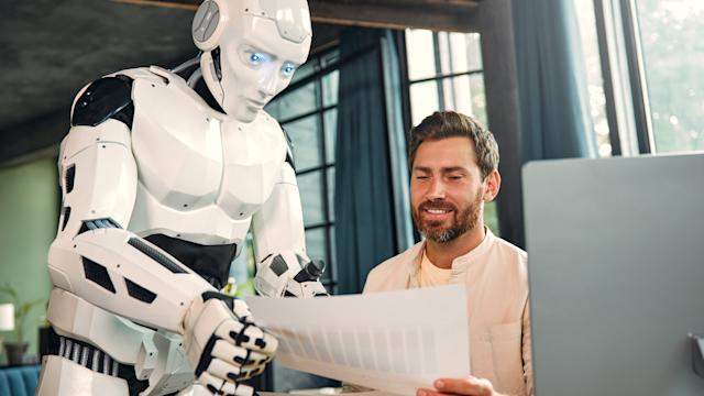 A robot talks to a worker in an office.
