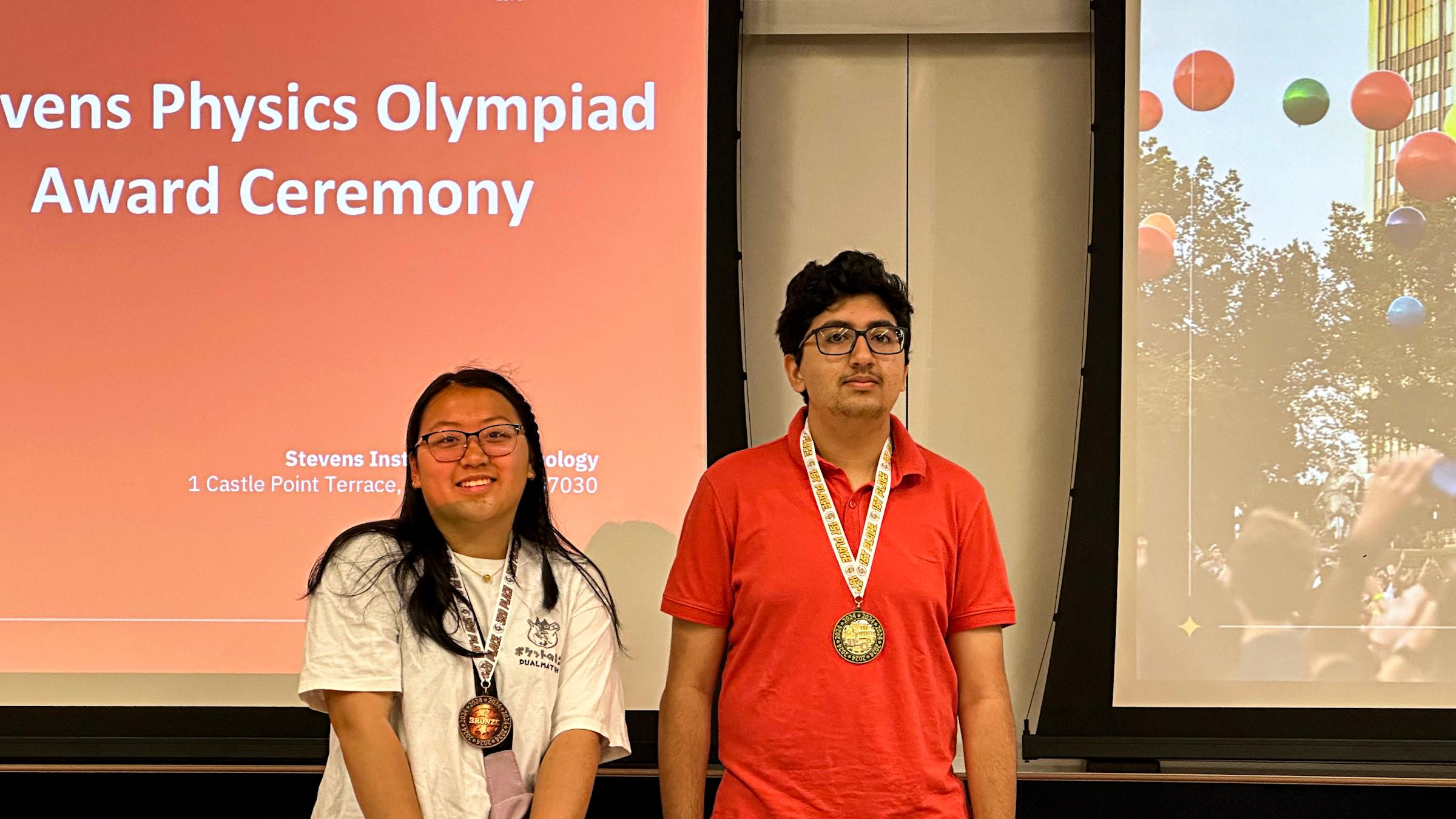 Two of the winners from the 2024 Physics Olympiad smiling with their medals.
