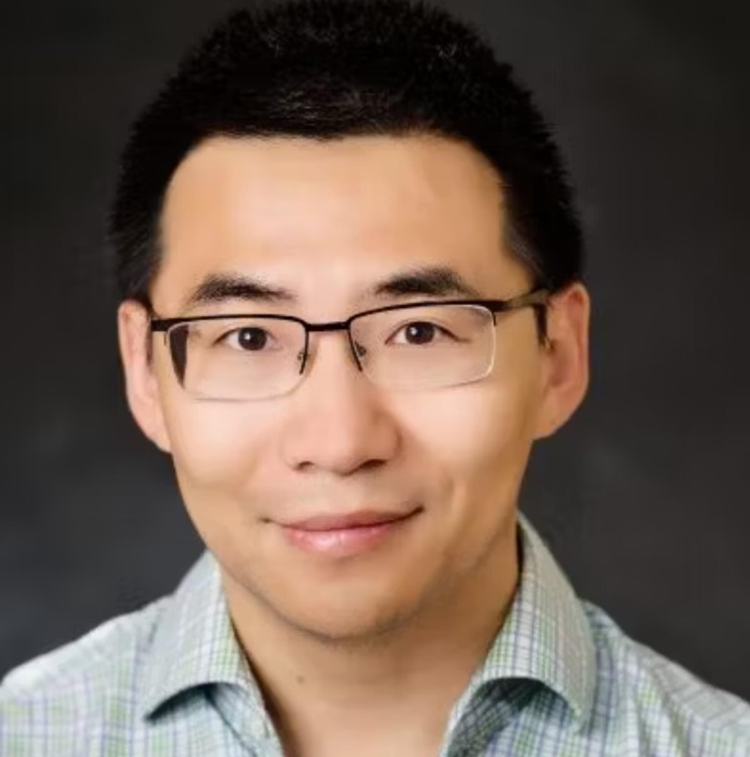 Headshot/professional portrait of Zhuo Feng, who is wearing a white collared shirt