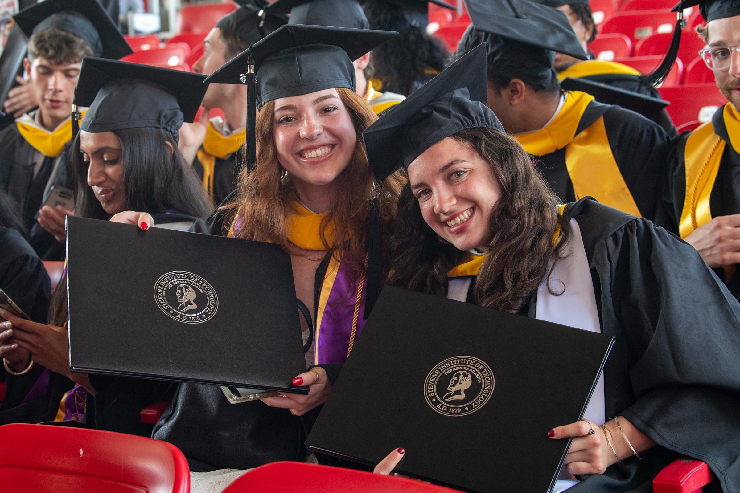 Two Women Graduates with Diplomas