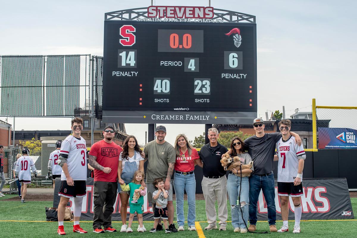 The Creamer family, including Blake ’25 (far left), Bryan ’25 (far right) and parents Nadine and Dale (center) pictured below the scoreboard