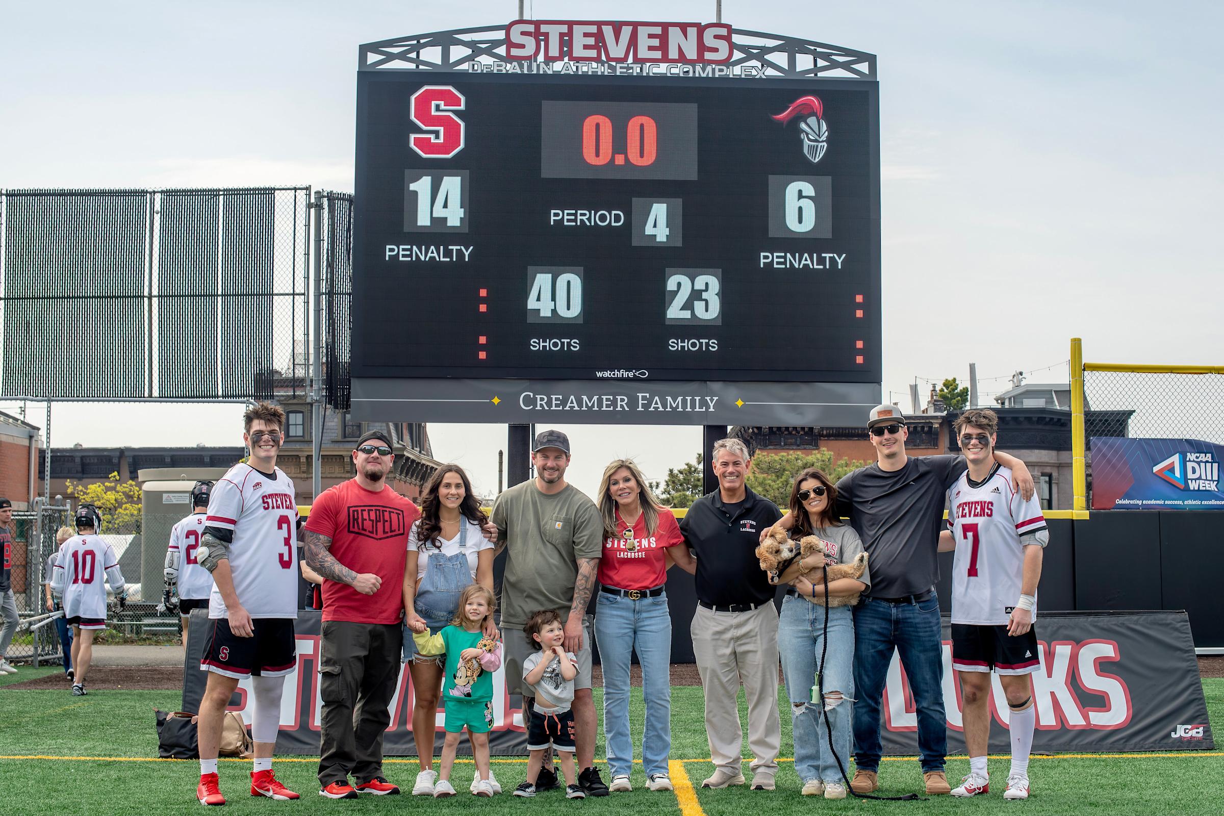 The Creamer family, including Blake ’25 (far left), Bryan ’25 (far right) and parents Nadine and Dale (center) pictured below the scoreboard