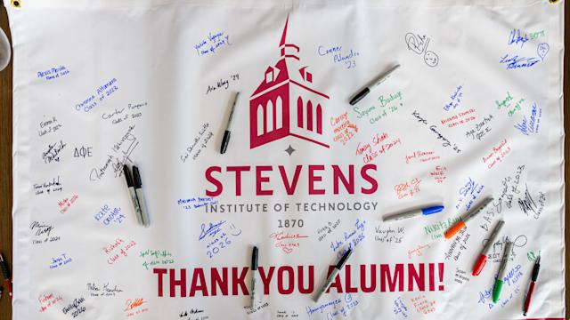 Students sign banner thanking Stevens alumni