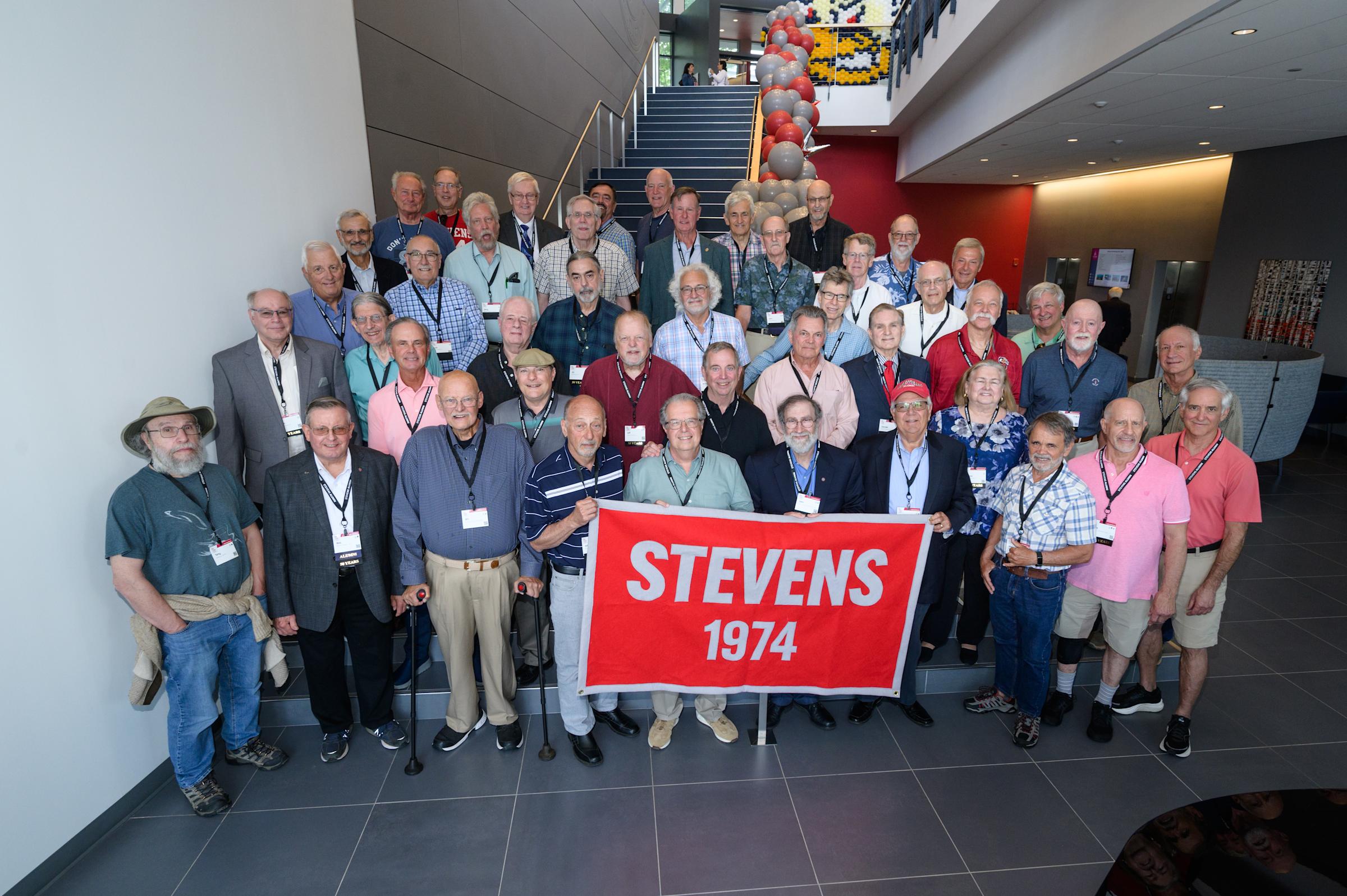 Members of the Class of 1974 pose for a photo on the steps inside the UCC during Alumni Weekend
