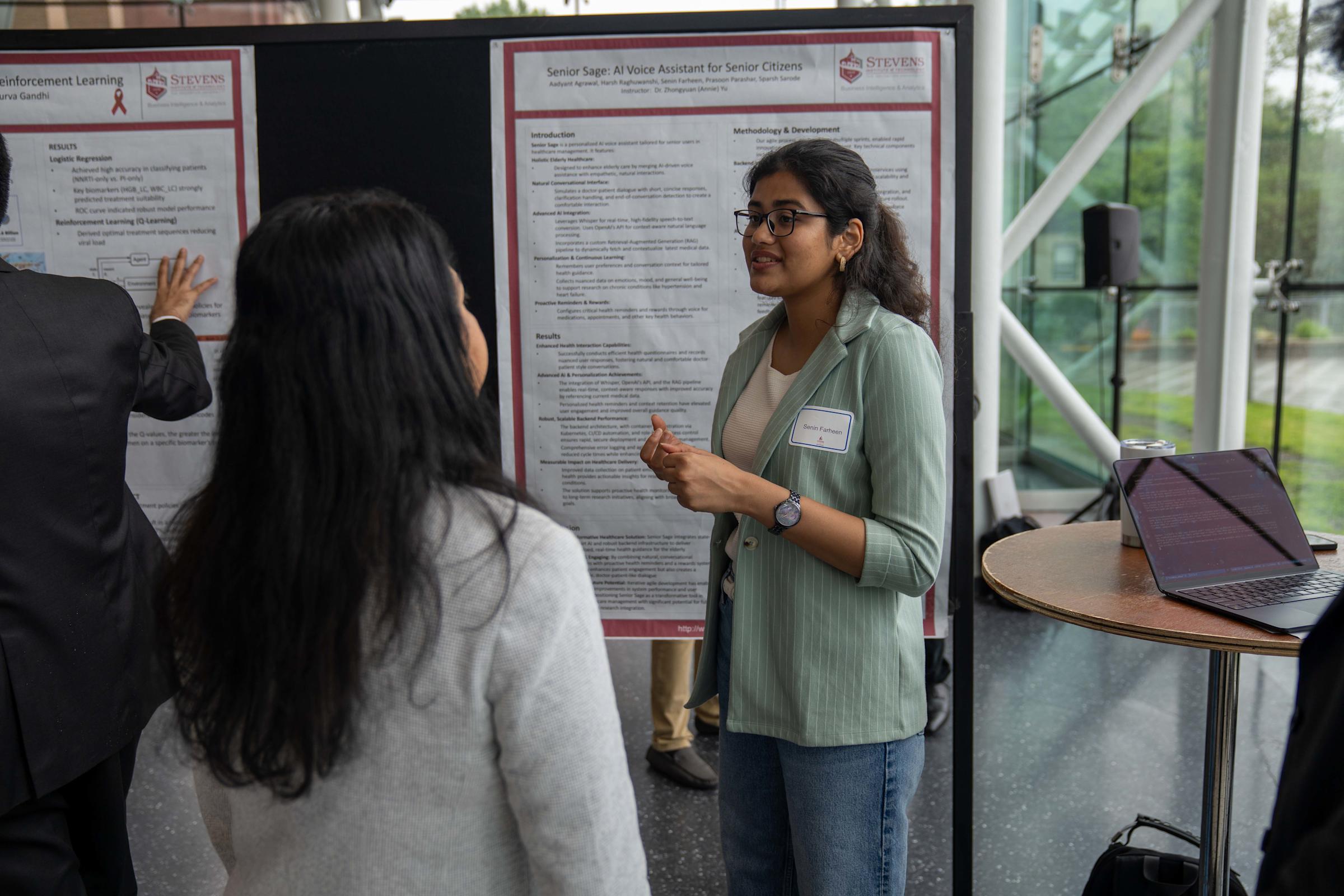 Two students pose in front of their research
