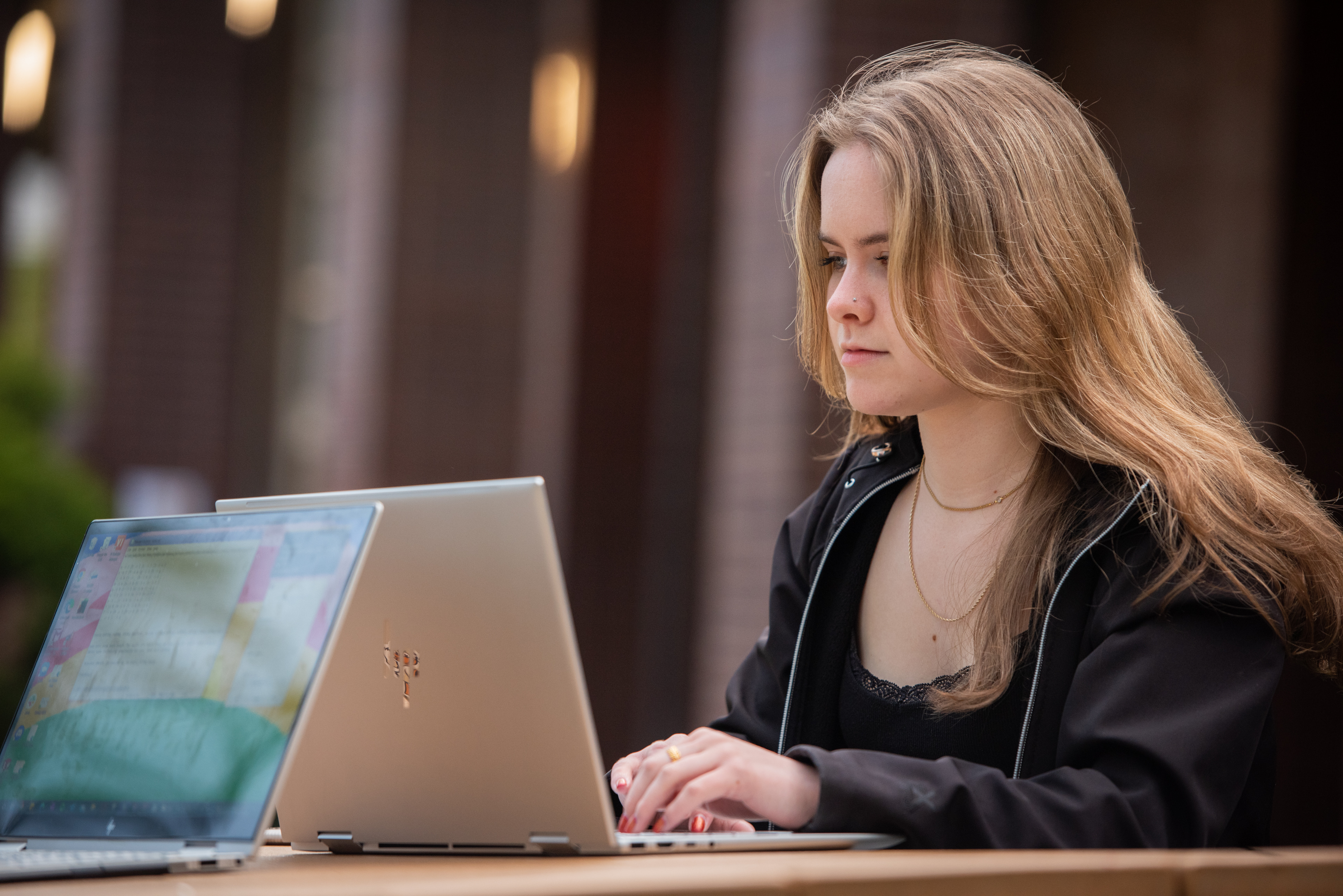 Student working on laptop outdoors