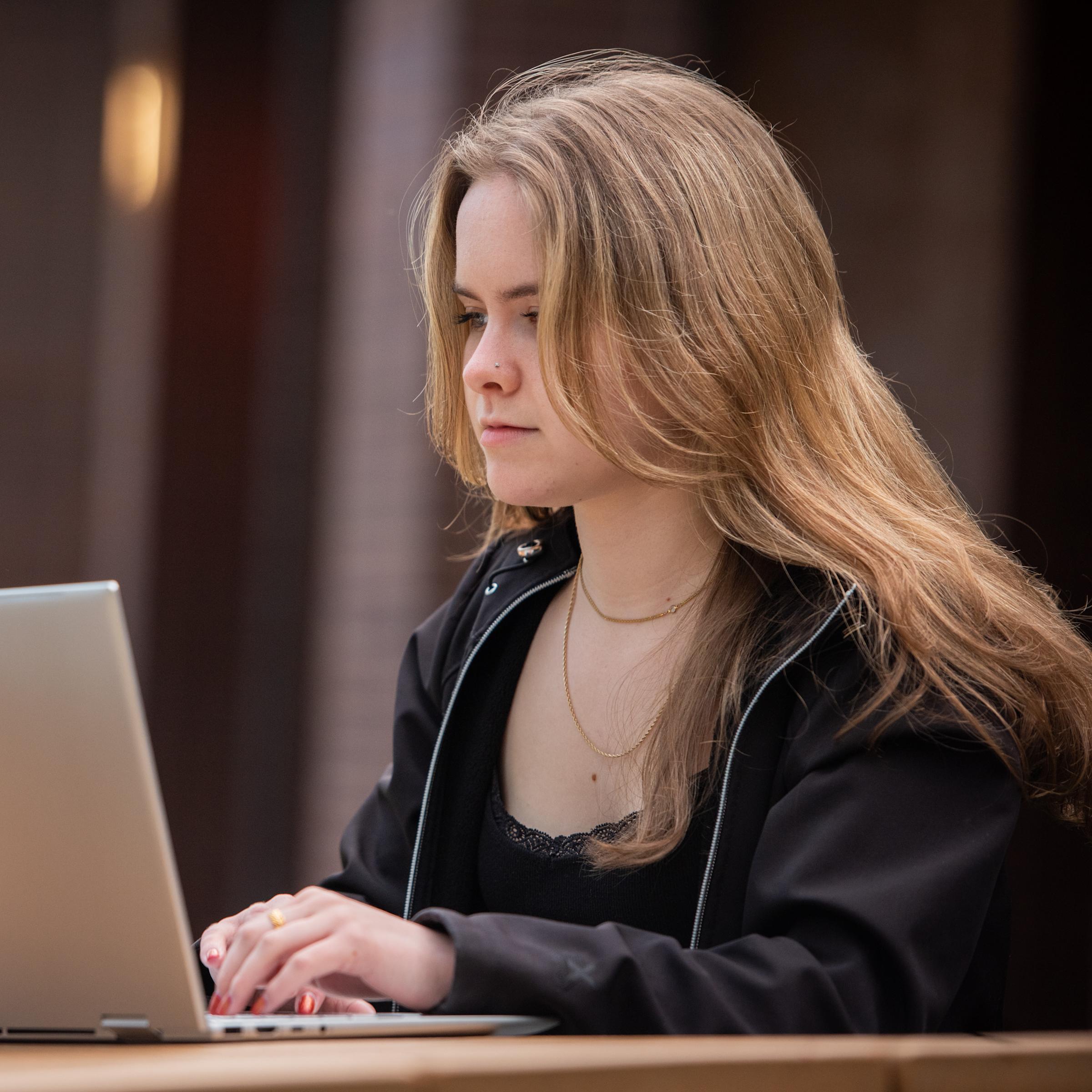 Student working on laptop outdoors
