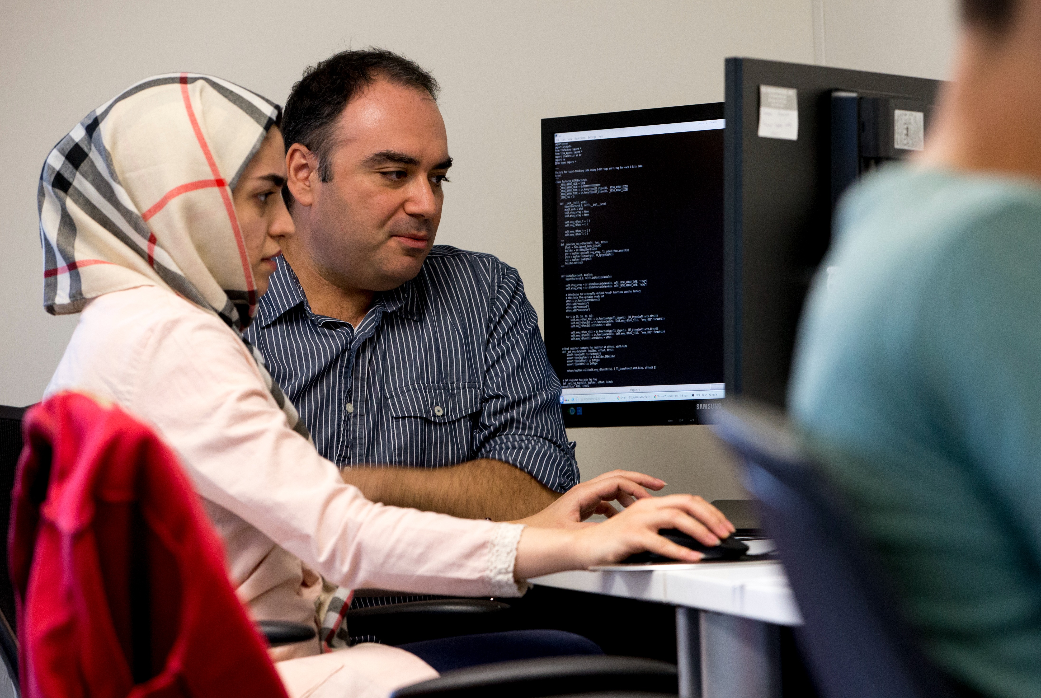 Computer Science faculty member Georgios Portokalidis instructs a student in front of a monitor.
