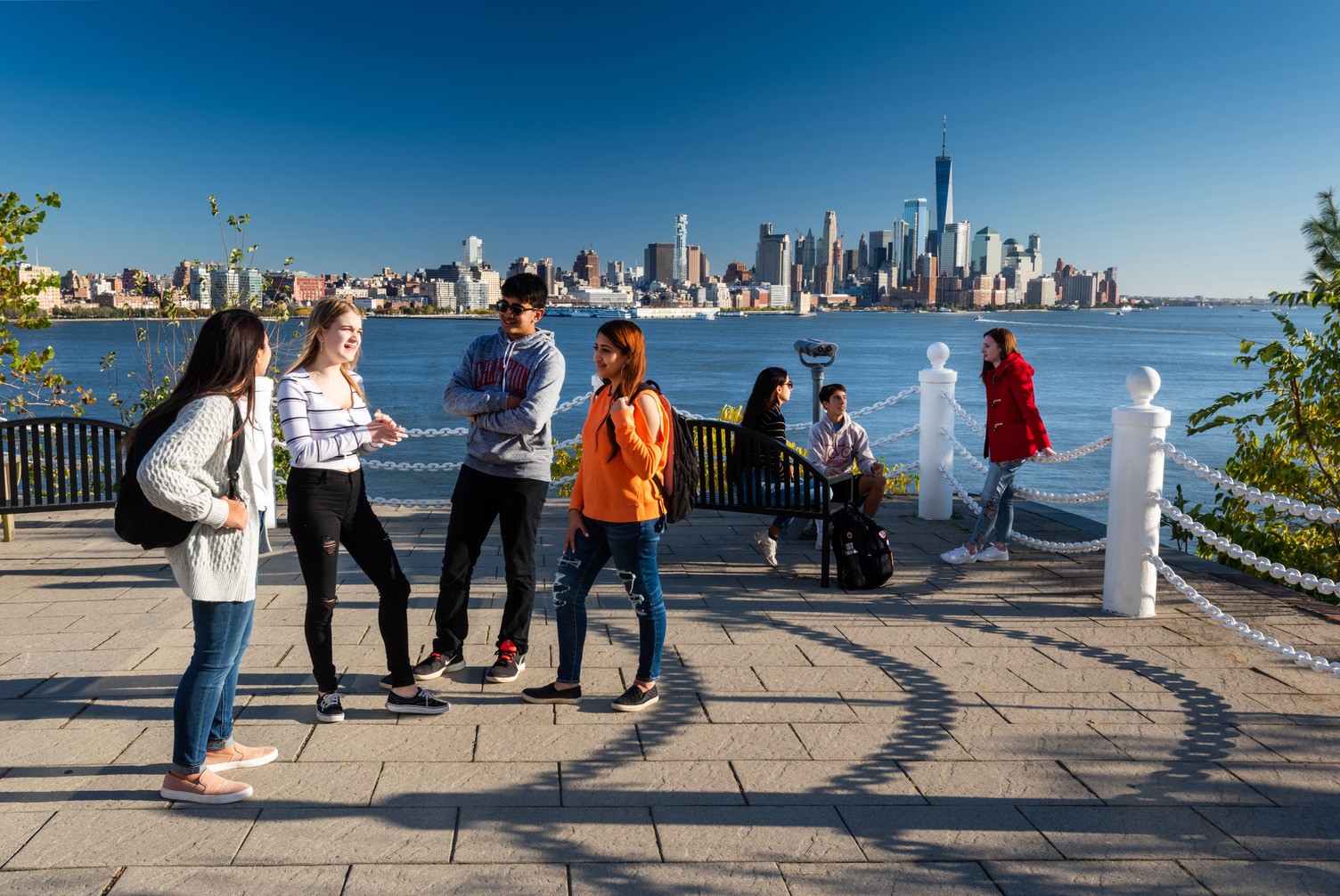 four students standing in a semicircle smiling at one another