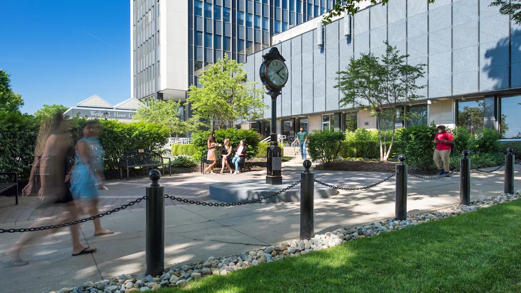 Stevens students walking on campus in front of clock.
