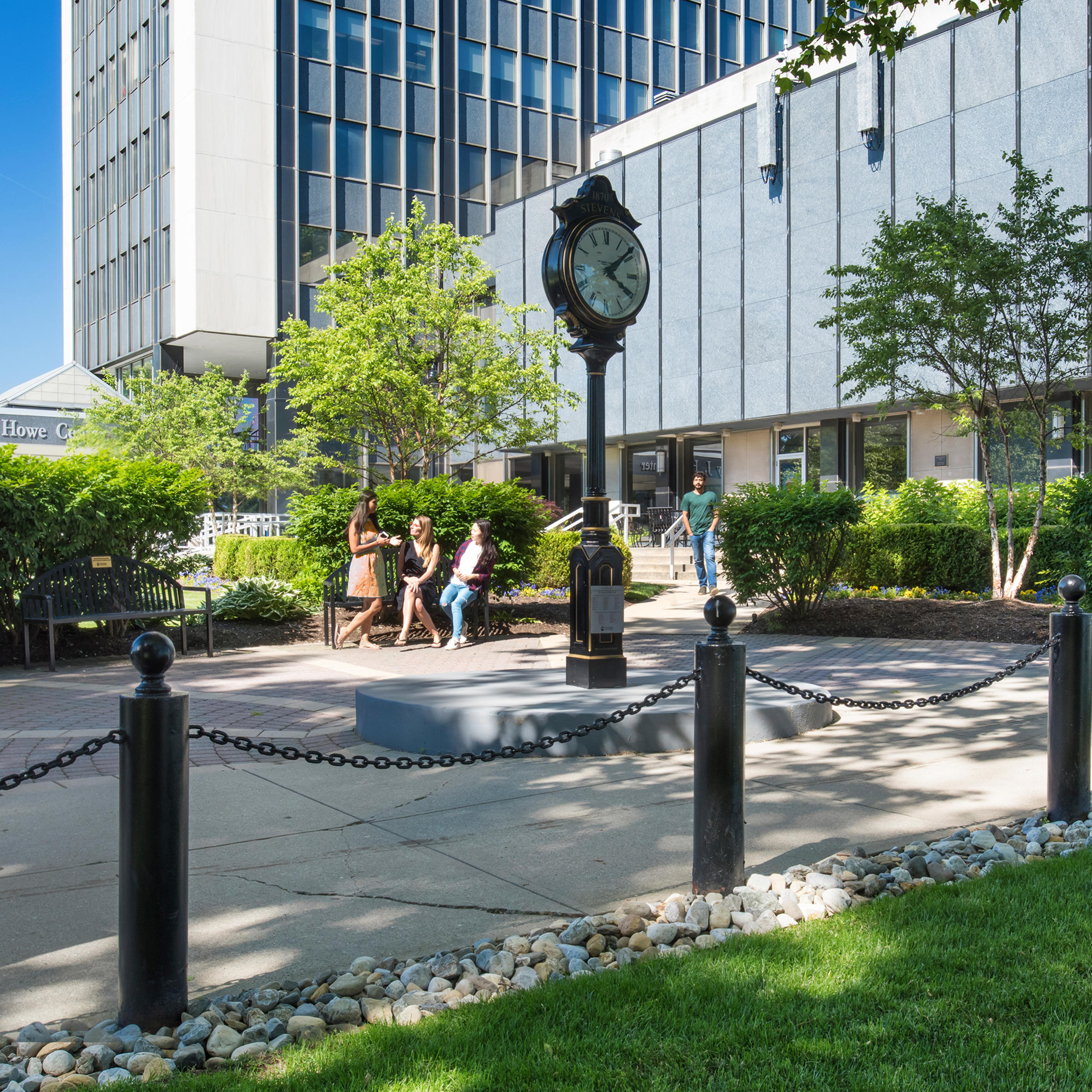 Stevens students walking on campus in front of clock.
