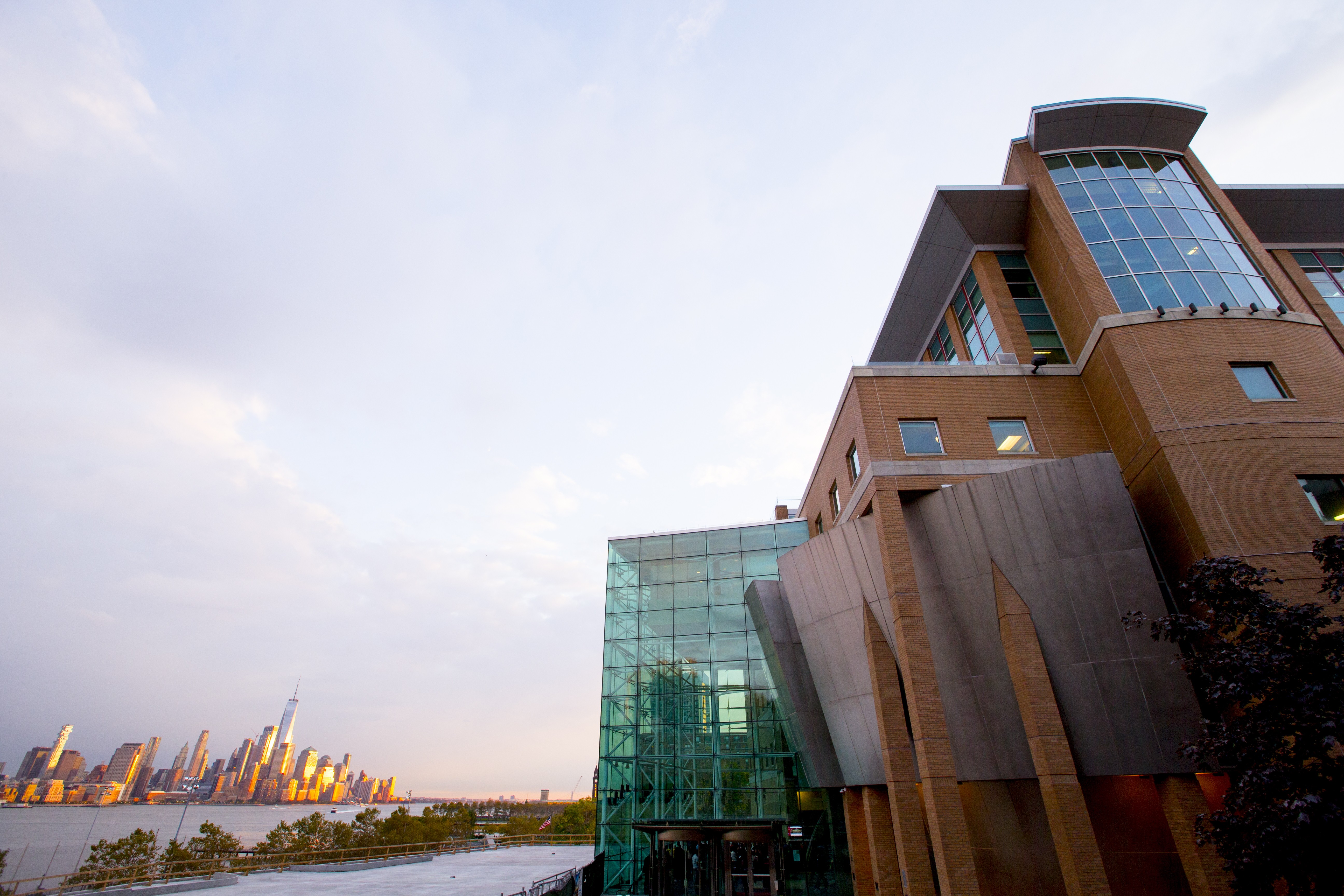 Exterior of the Babbio Center on the Stevens campus overlooking the New York City skyline in the background.